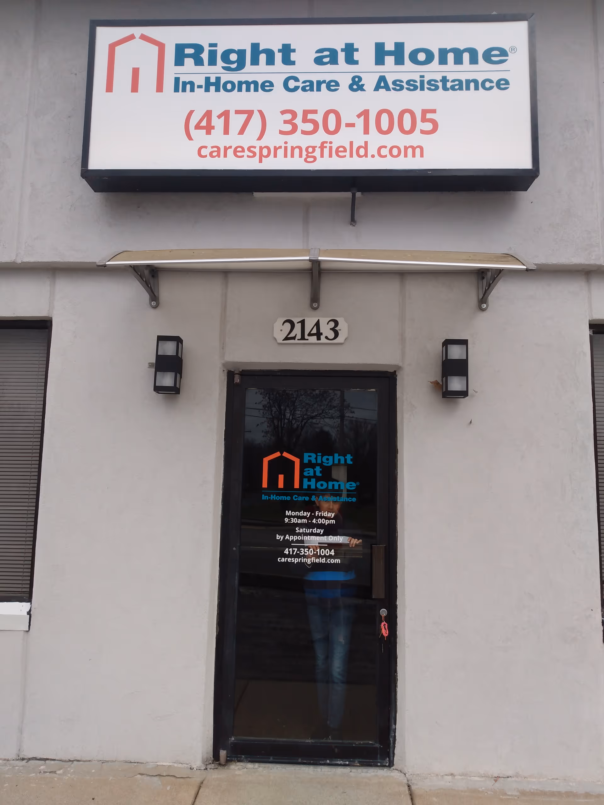 Facade of Right at Home facility with large sign, address 2143, glass door entrance.