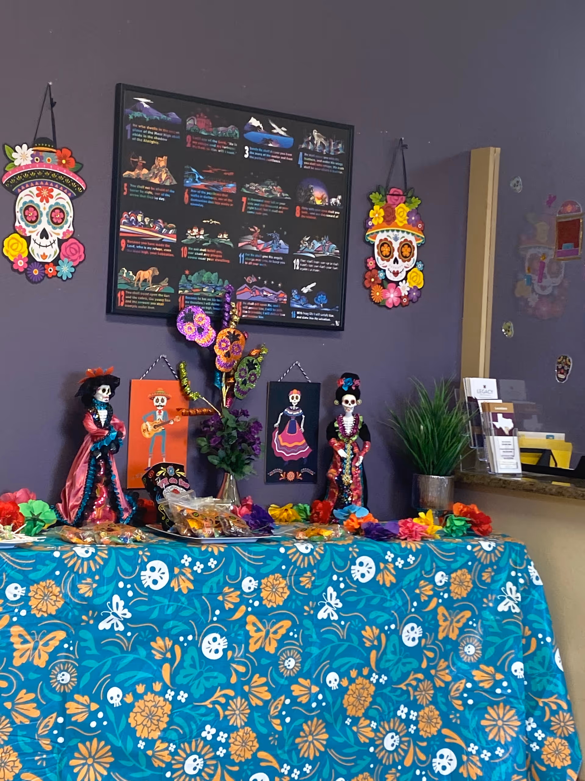 Interior display of Day of the Dead decorations: skulls, flowers, and vibrant fabrics.