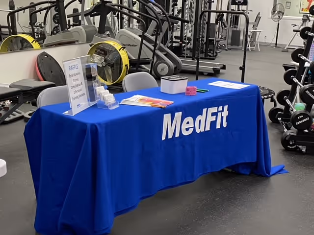 Blue MedFit information table in a gym interior at Transition Care Telemetry.