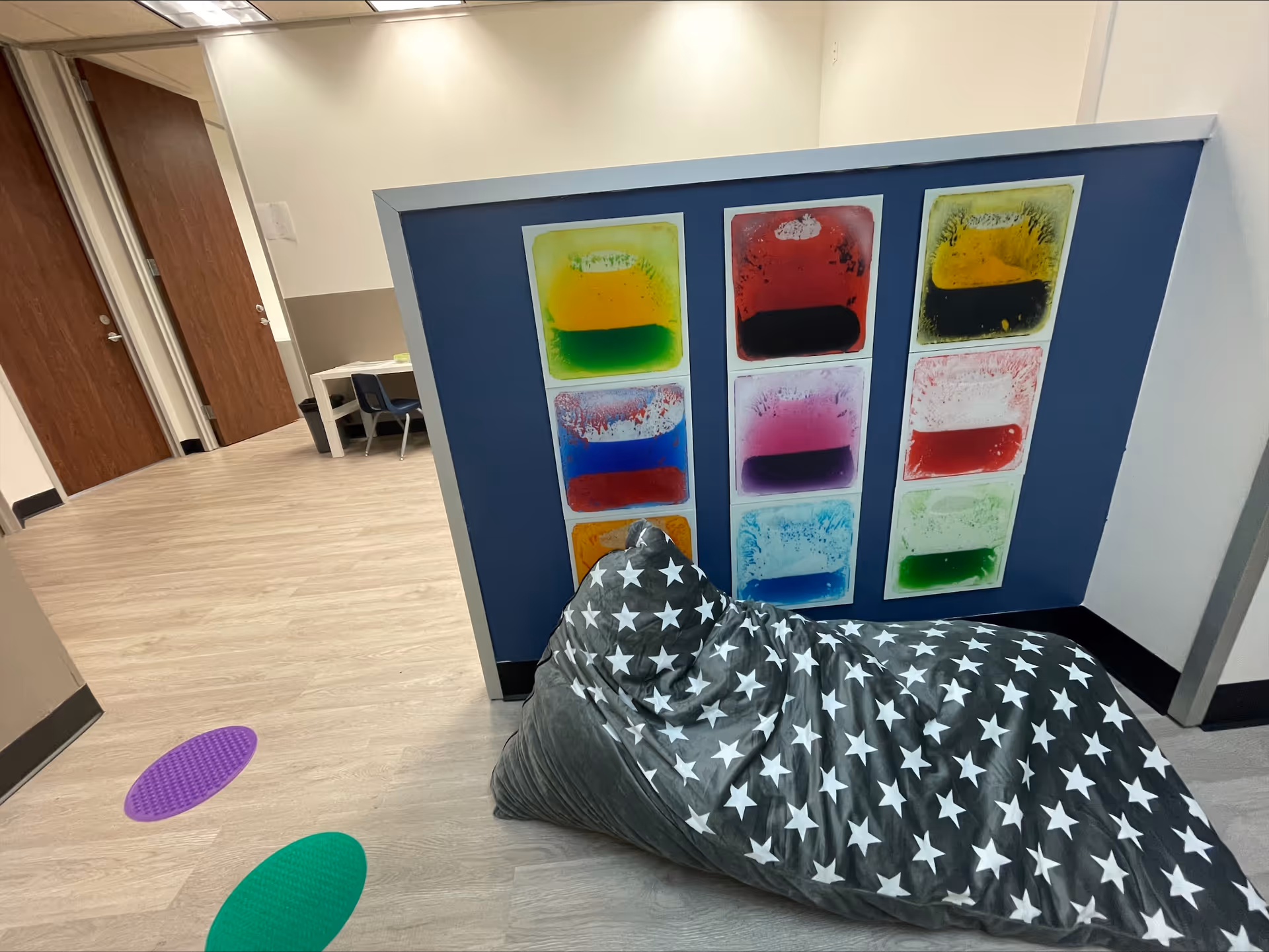 Colorful wall panels and a star-patterned bean bag in a bright interior hallway.