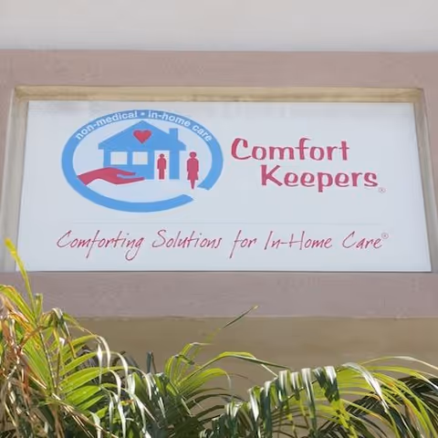 Exterior sign for Comfort Keepers Home Care with logo and landscaping.