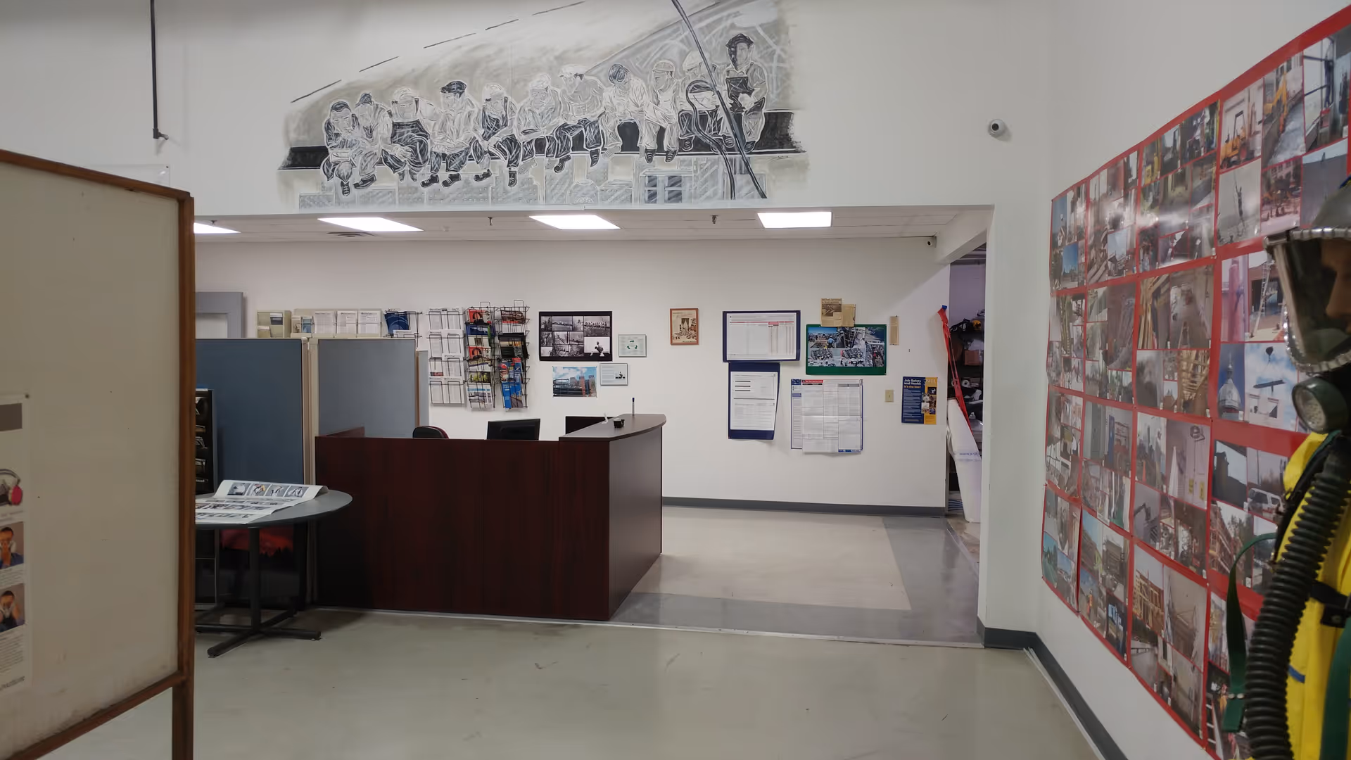 Interior lobby of a senior facility with reception desk, bulletin boards, and photo wall.