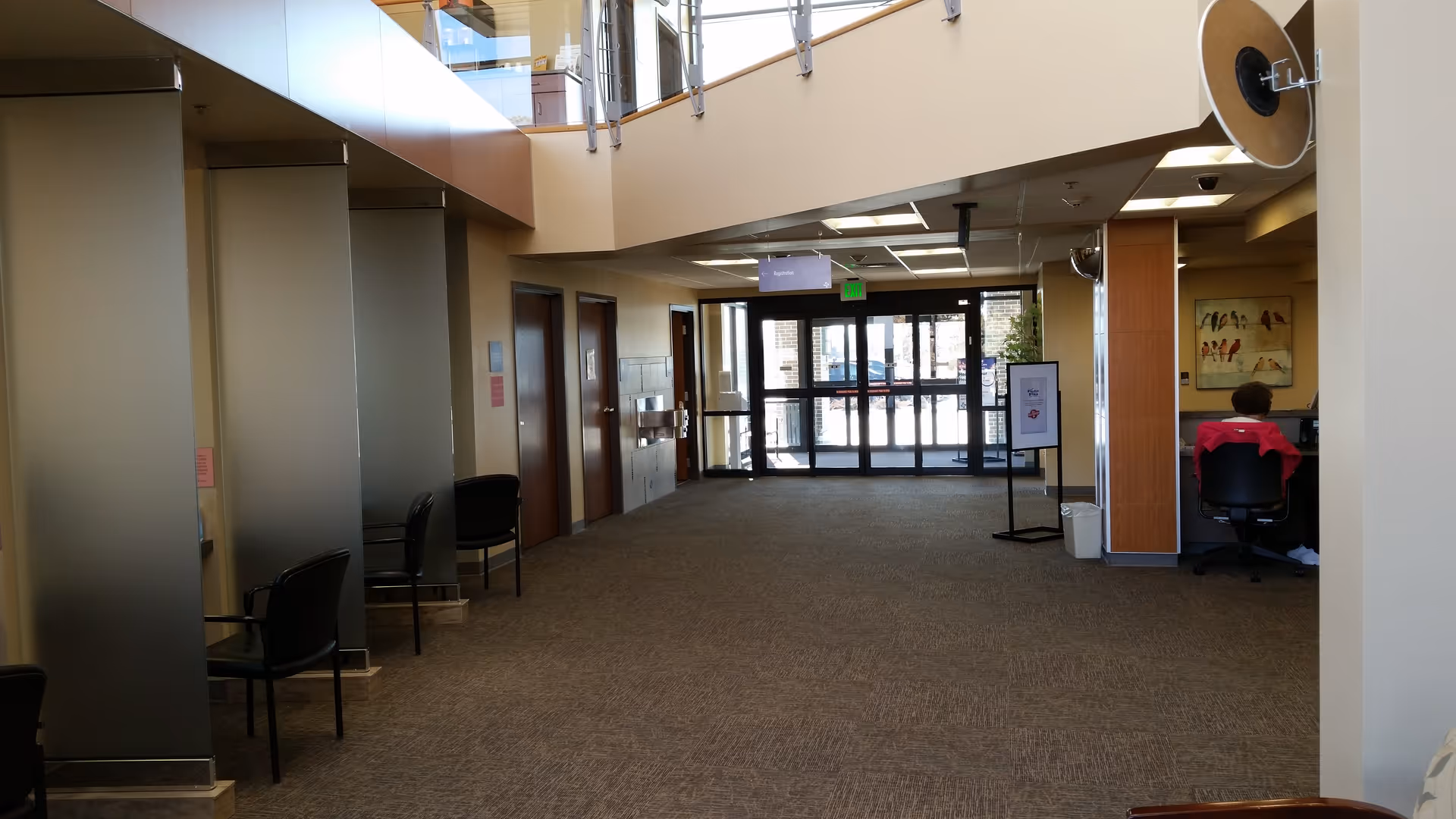Bright interior lobby with seating along the left and a receptionist desk on the right.