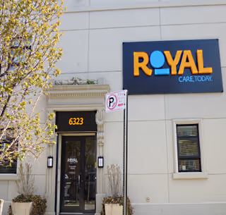 Exterior view of a senior living facility entrance with Royal Care sign.