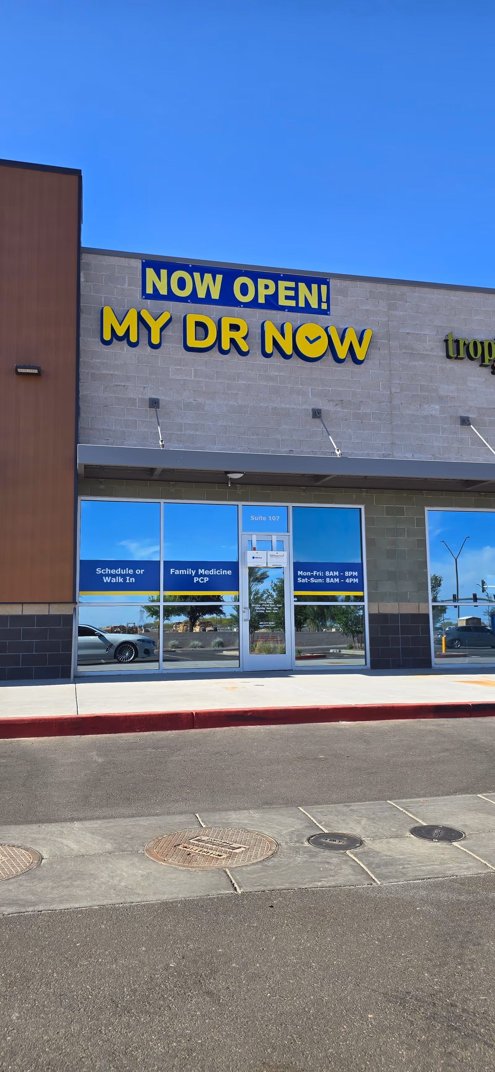 Exterior storefront with large NOW OPEN MY DR NOW signage above glass doors
