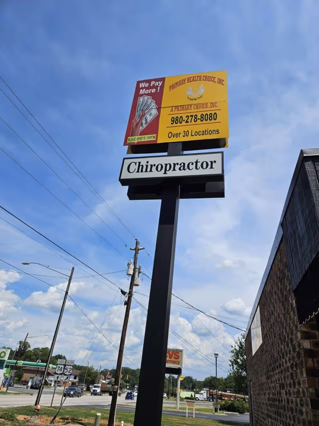 Tall outdoor sign advertising Chiropractor and Primary Health Choice on a street.