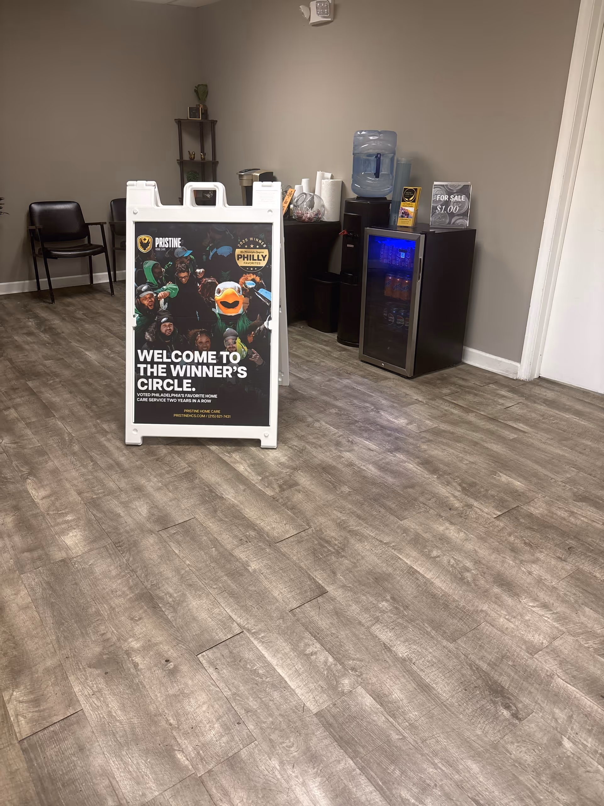 Lobby area with a large 'Welcome to the Winner's Circle' sign, seating, and beverage station.