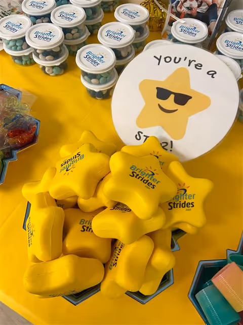 Close-up of Brighter Strides promotional items on a bright yellow display table.