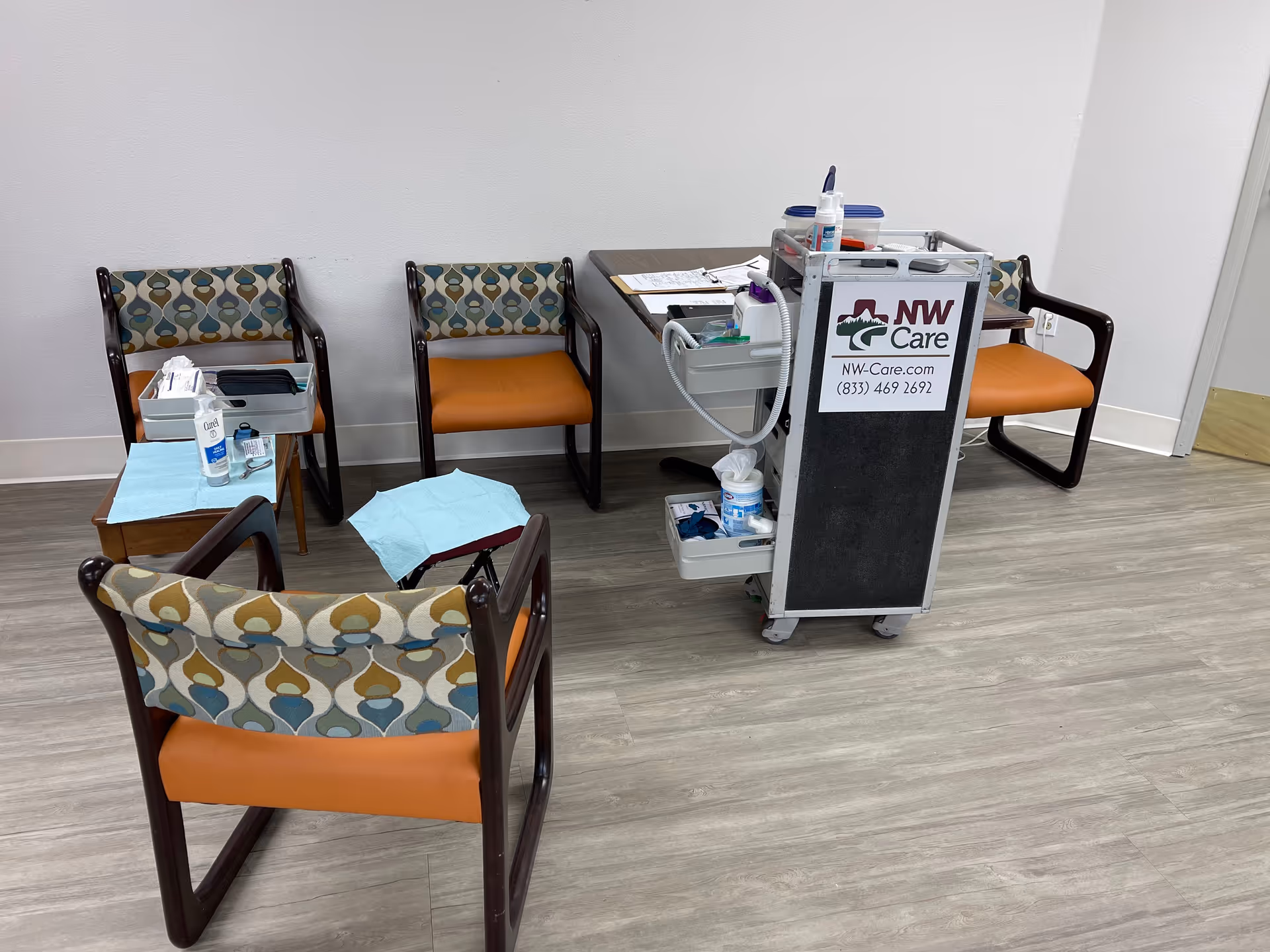 Clinic podiatry station with a medical cart and several empty chairs.