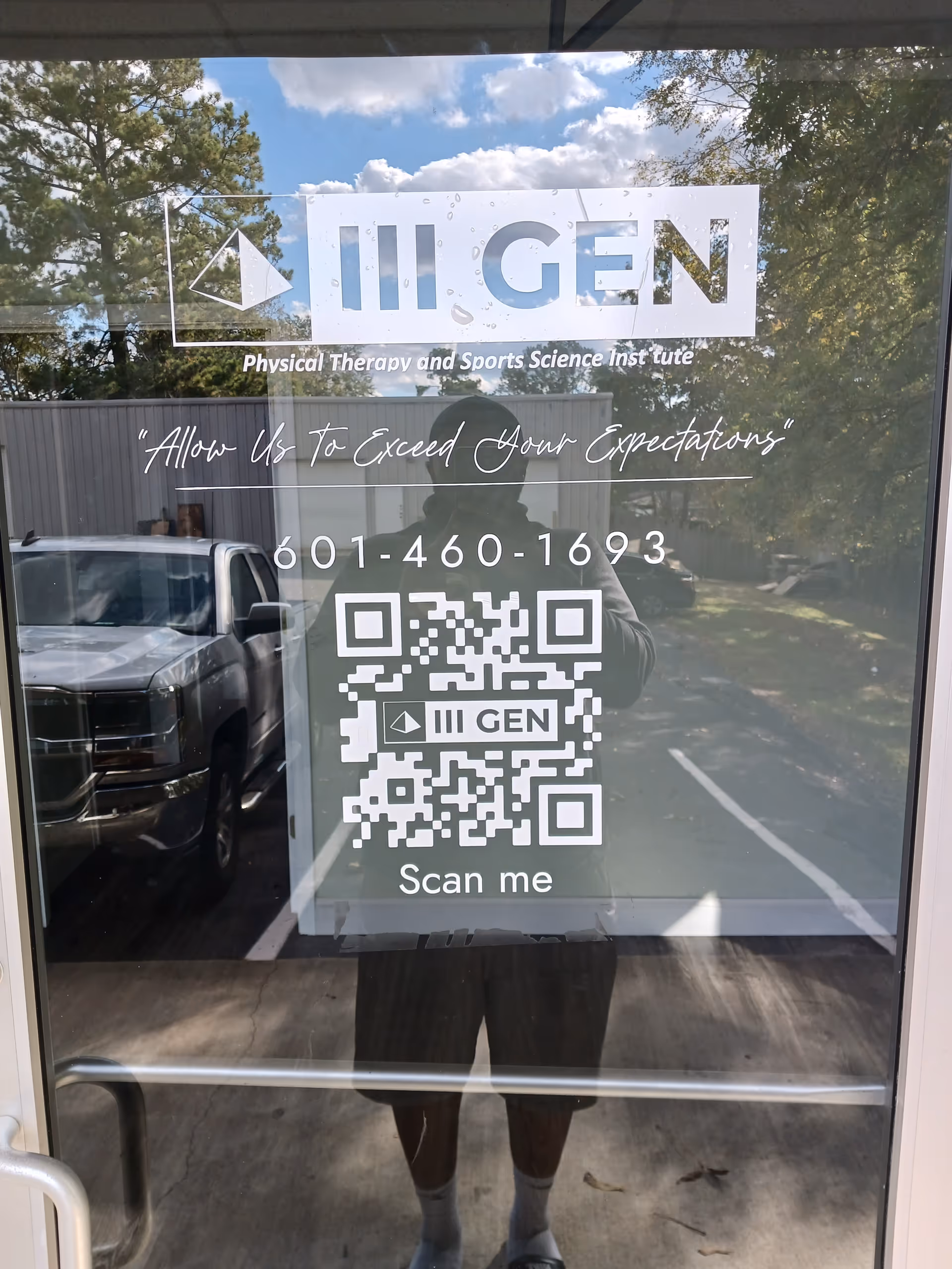 Glass door featuring III GEN sign, QR code, and a reflected person outside.