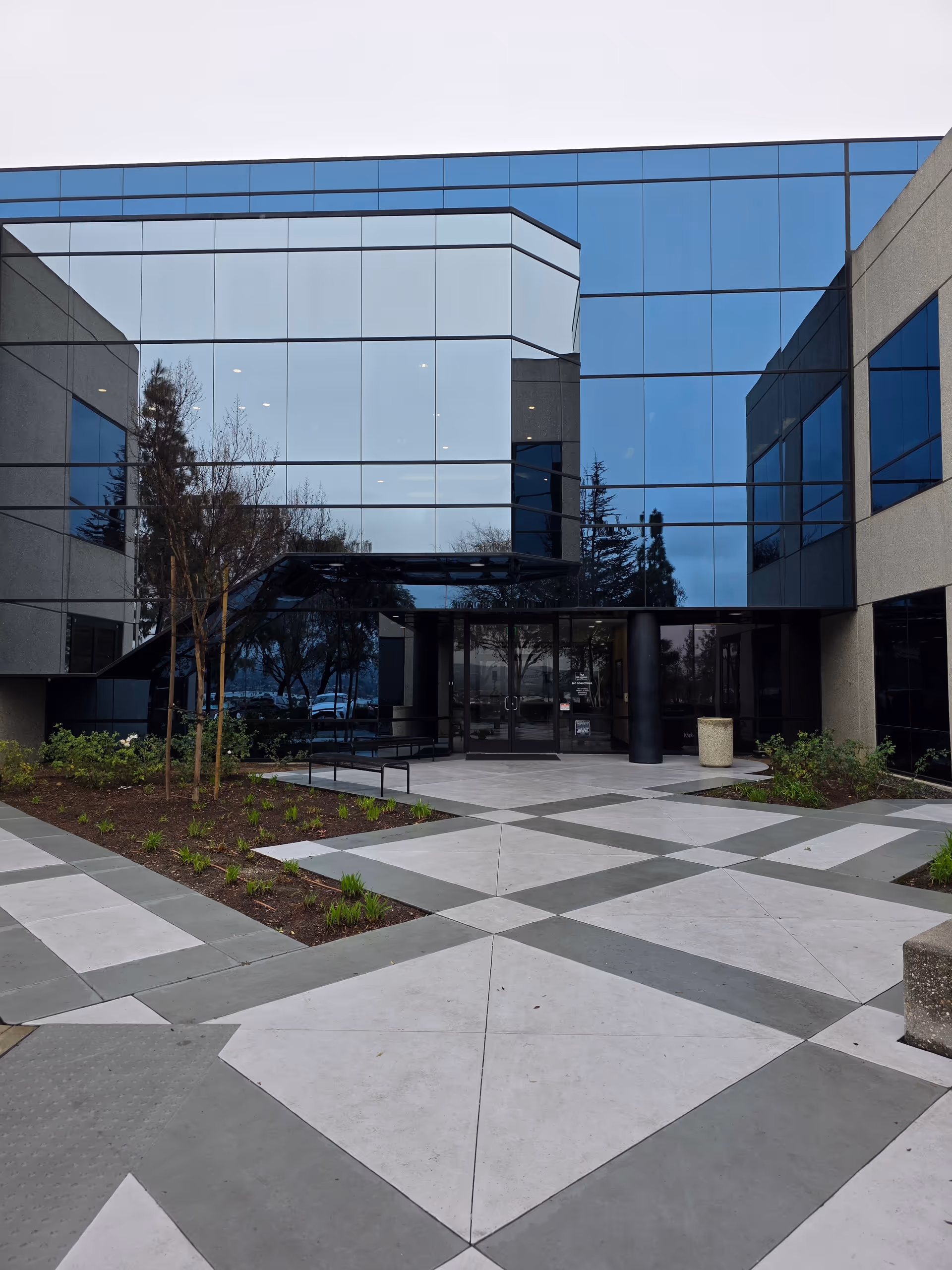 Amada Senior Care building exterior with glass façade and geometric courtyard.