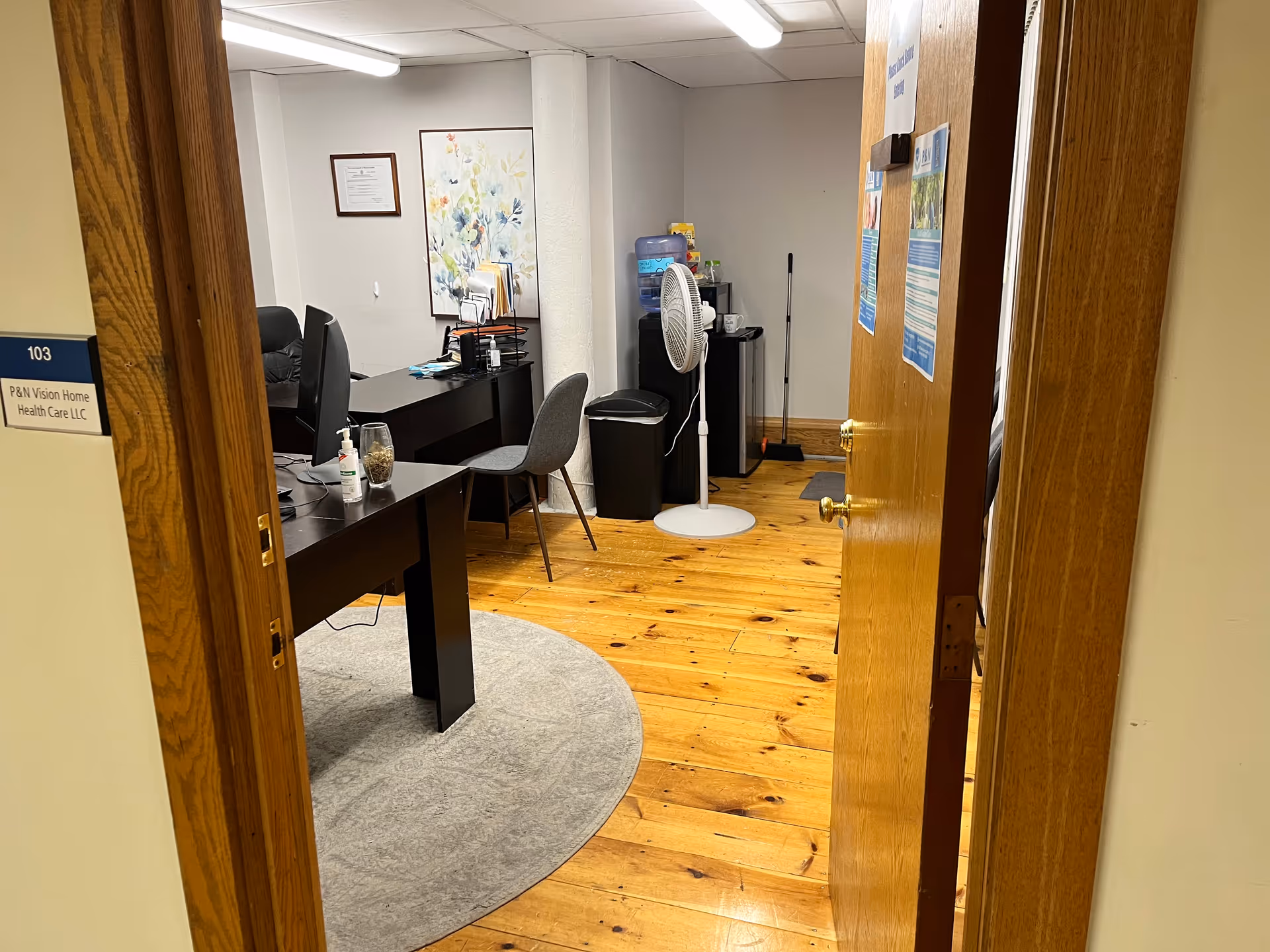 Interior office area at P&N Vision Home Health Care with desks and a standing fan.