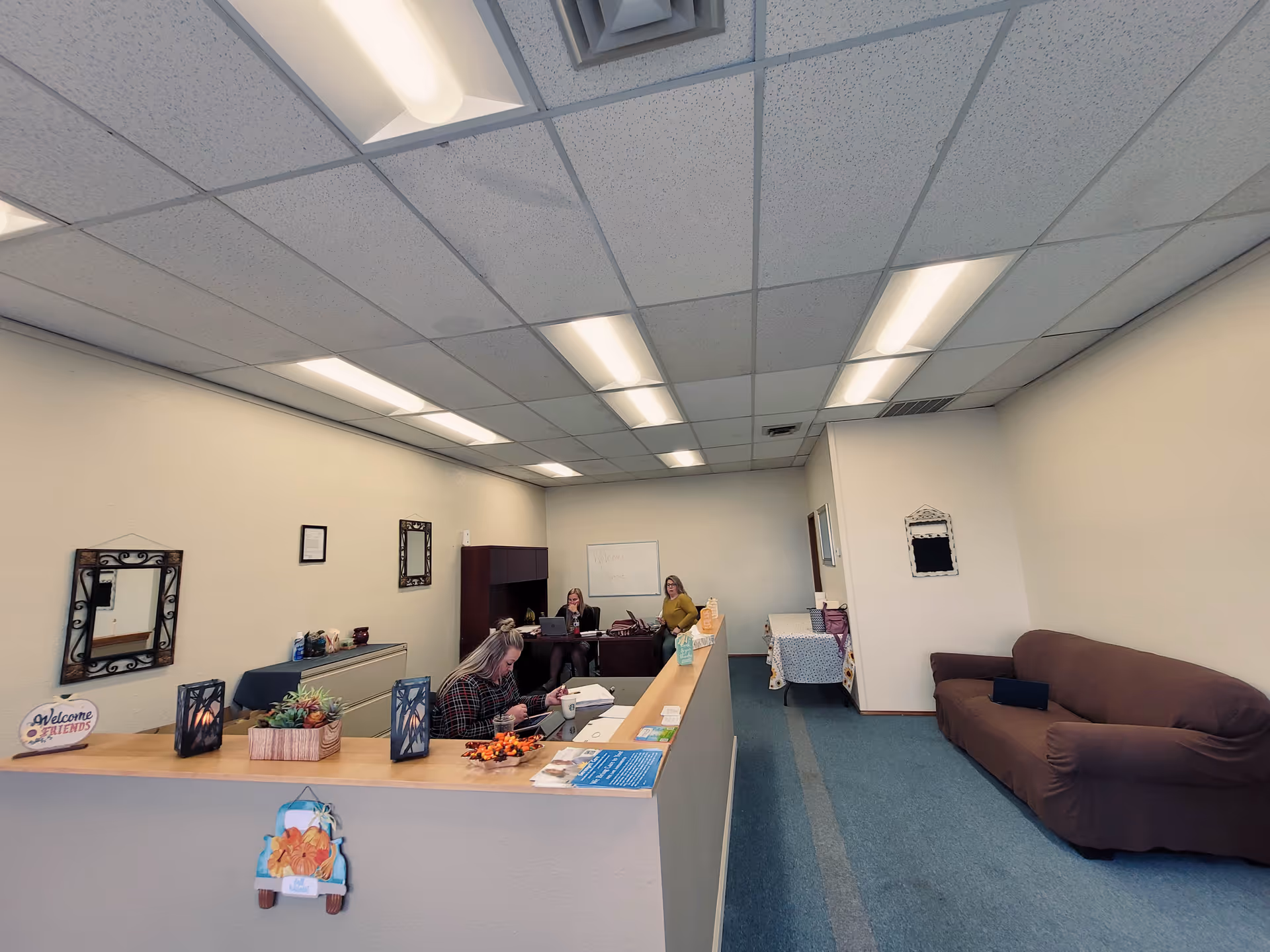 Interior reception area of Serengeti Care with a front desk, seating, and a brown sofa.