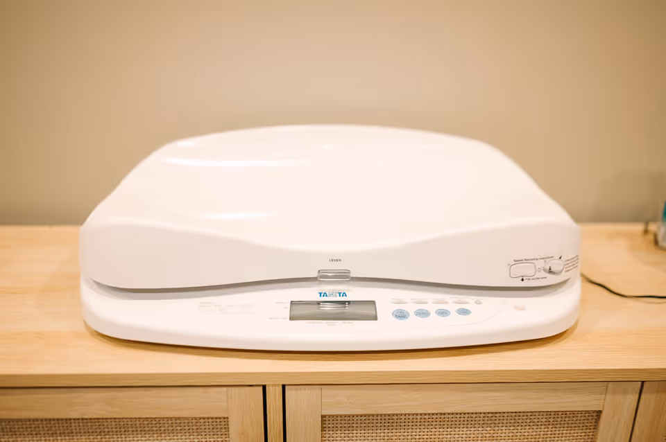 White medical device with a digital display sits on a wooden counter.