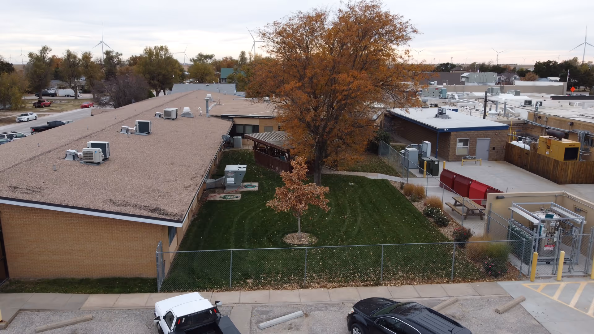 Aerial view of a hospital campus with a grassy yard and surrounding low buildings
