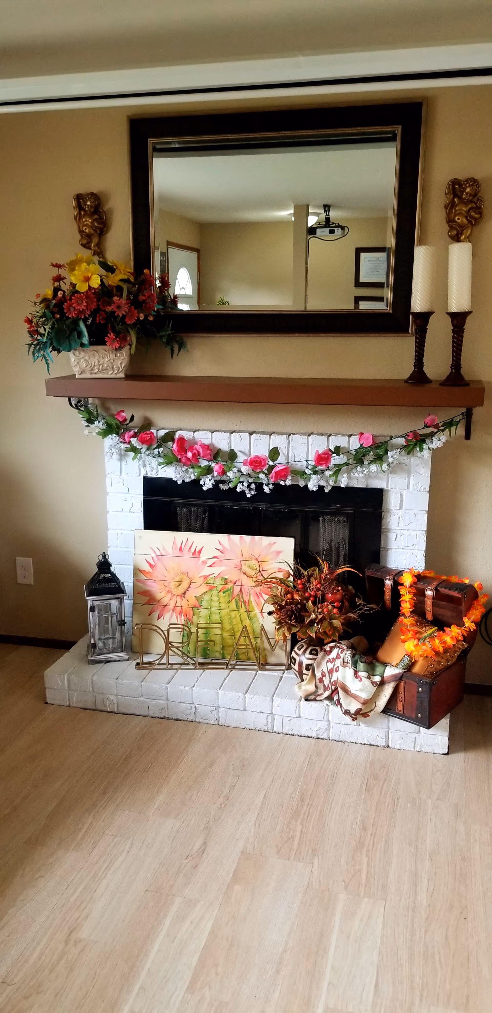 Decorated fireplace in a cozy living room with garland, flowers, and autumn decor.