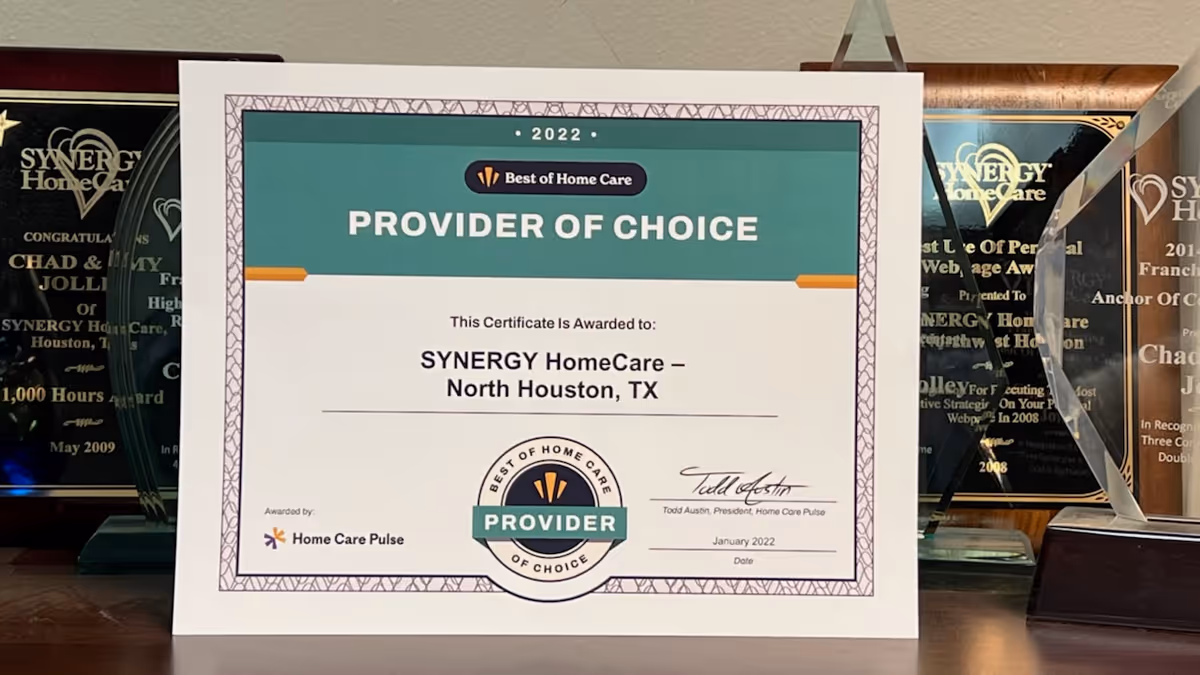 Certificate labeled Provider of Choice on a desk with SYNERGY HomeCare awards in the background.