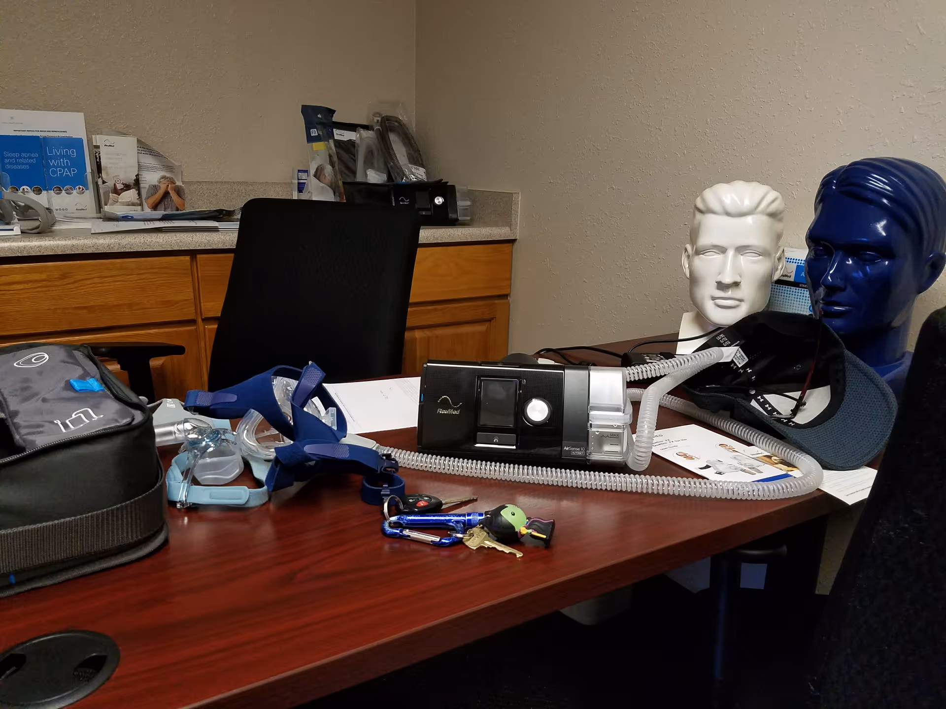 Medical equipment on a desk, including a CPAP machine, masks, and supplies.