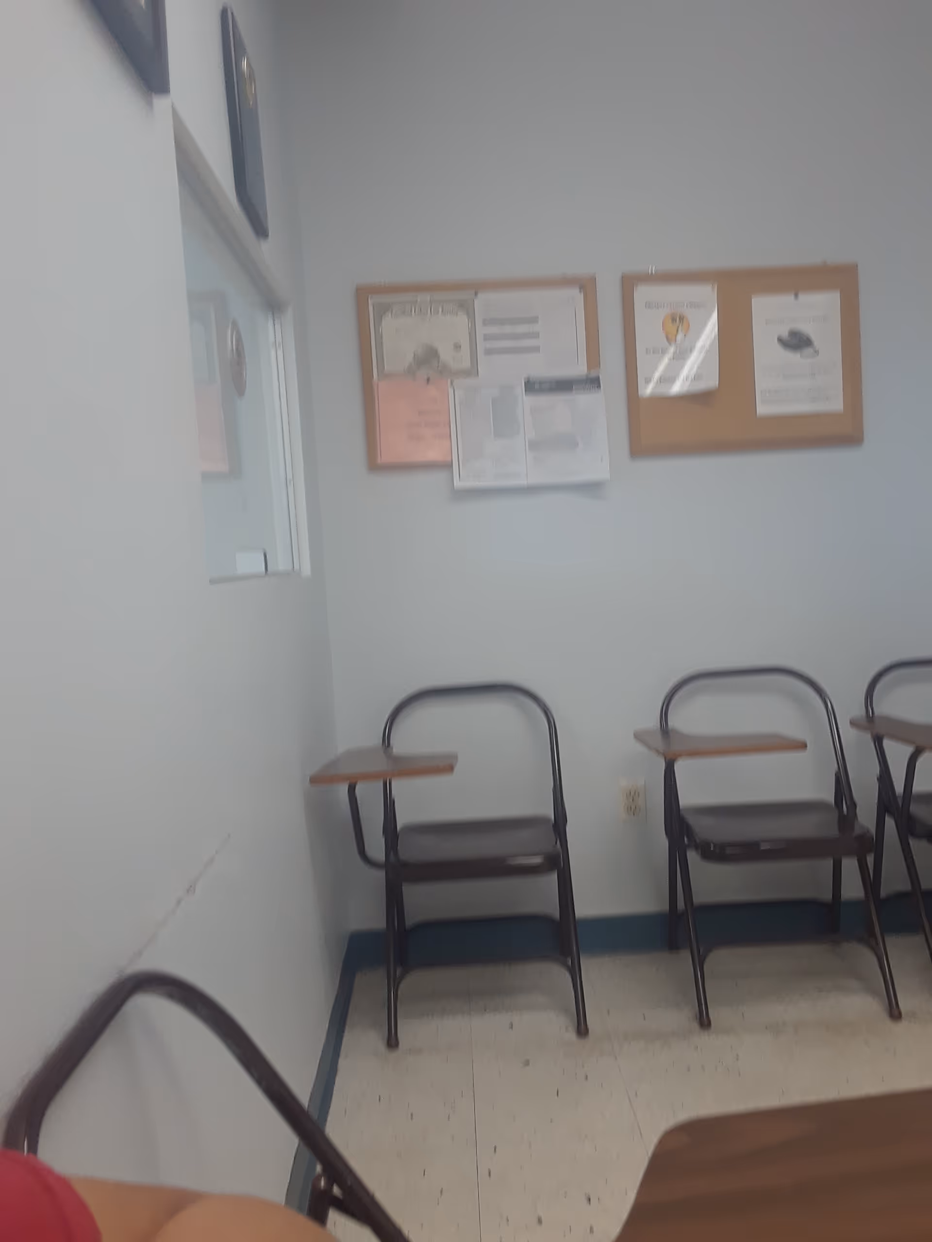 Empty room with metal chairs and bulletin boards on light blue walls.
