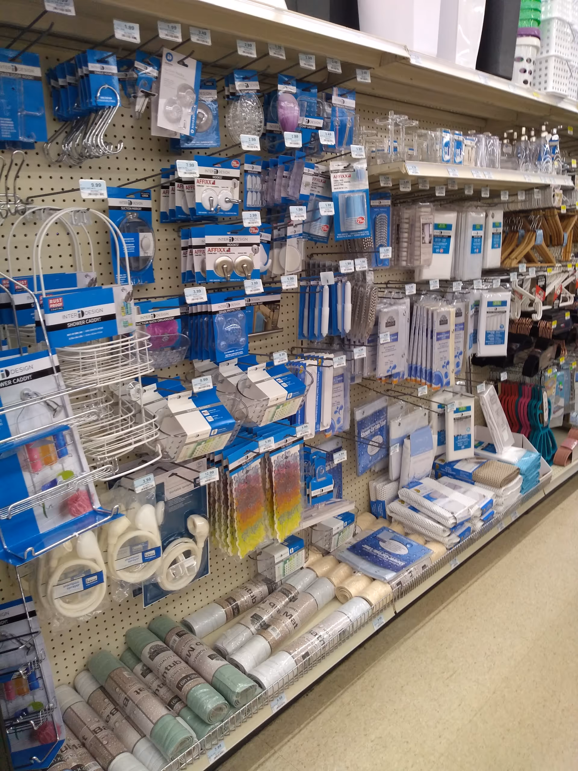Store aisle packed with bathroom accessories and toiletries on pegboard shelves.