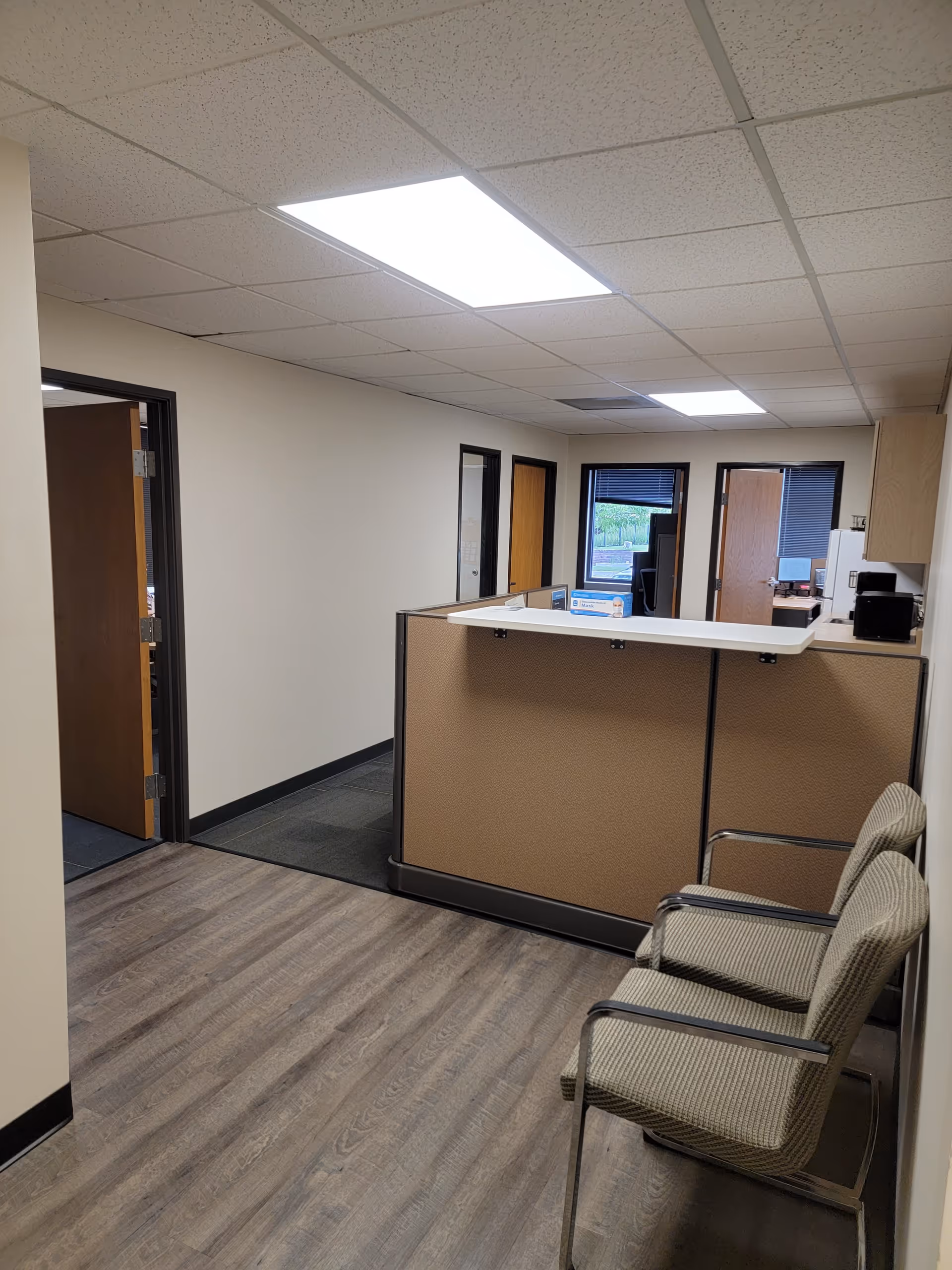 Interior reception area of a senior facility with a counter and waiting chairs.