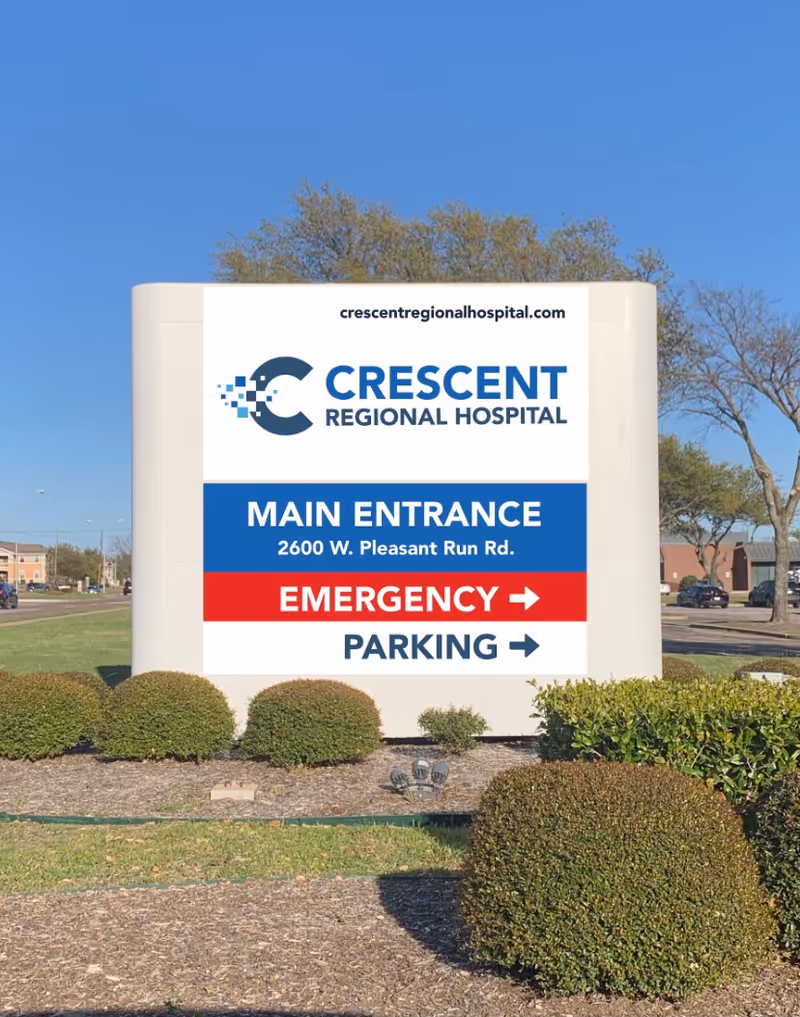 A large hospital sign announces Crescent Regional Hospital with main entrance and emergency parking.