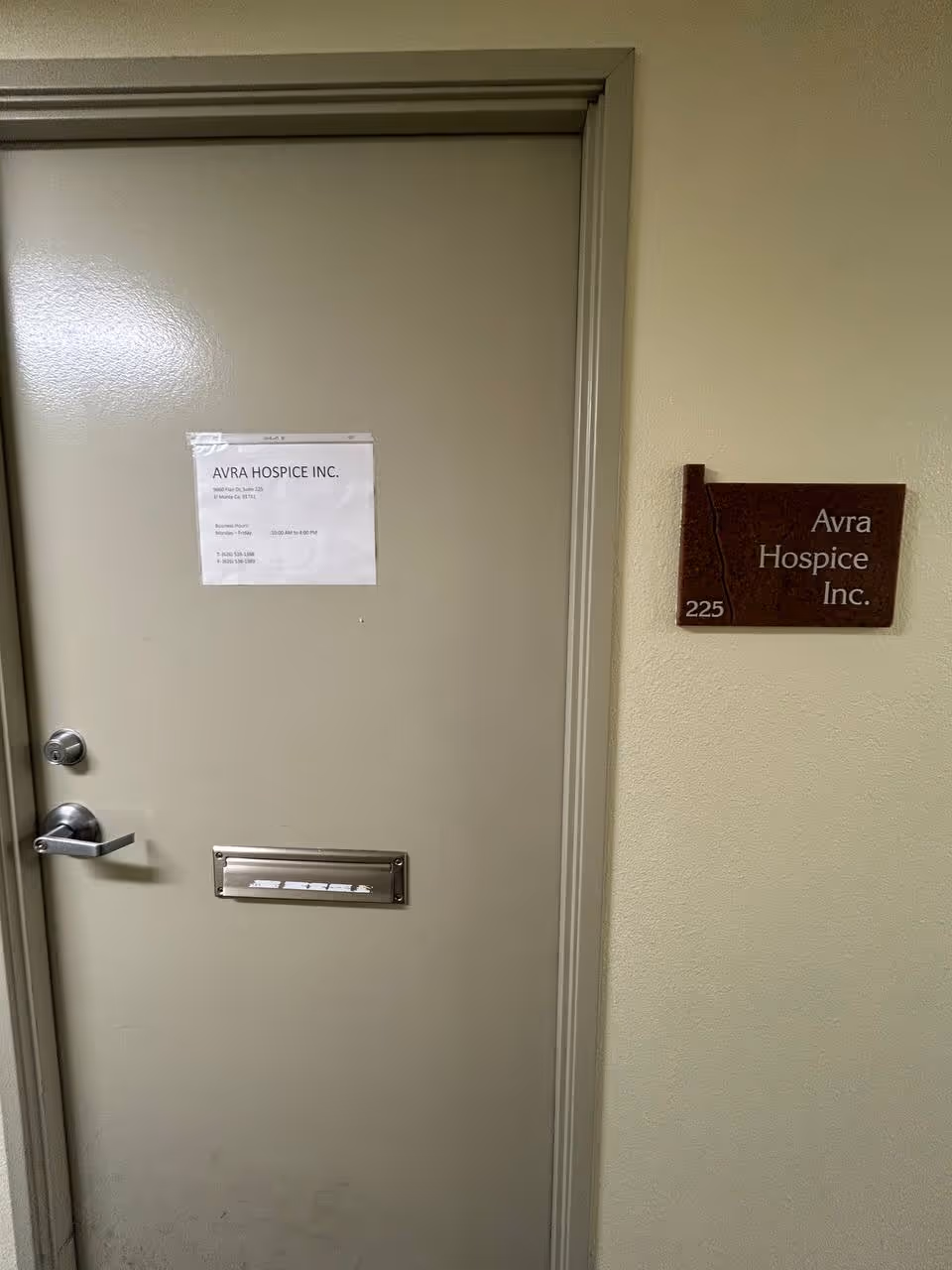 Interior hallway door with Avra Hospice Inc. sign and room number plaque.