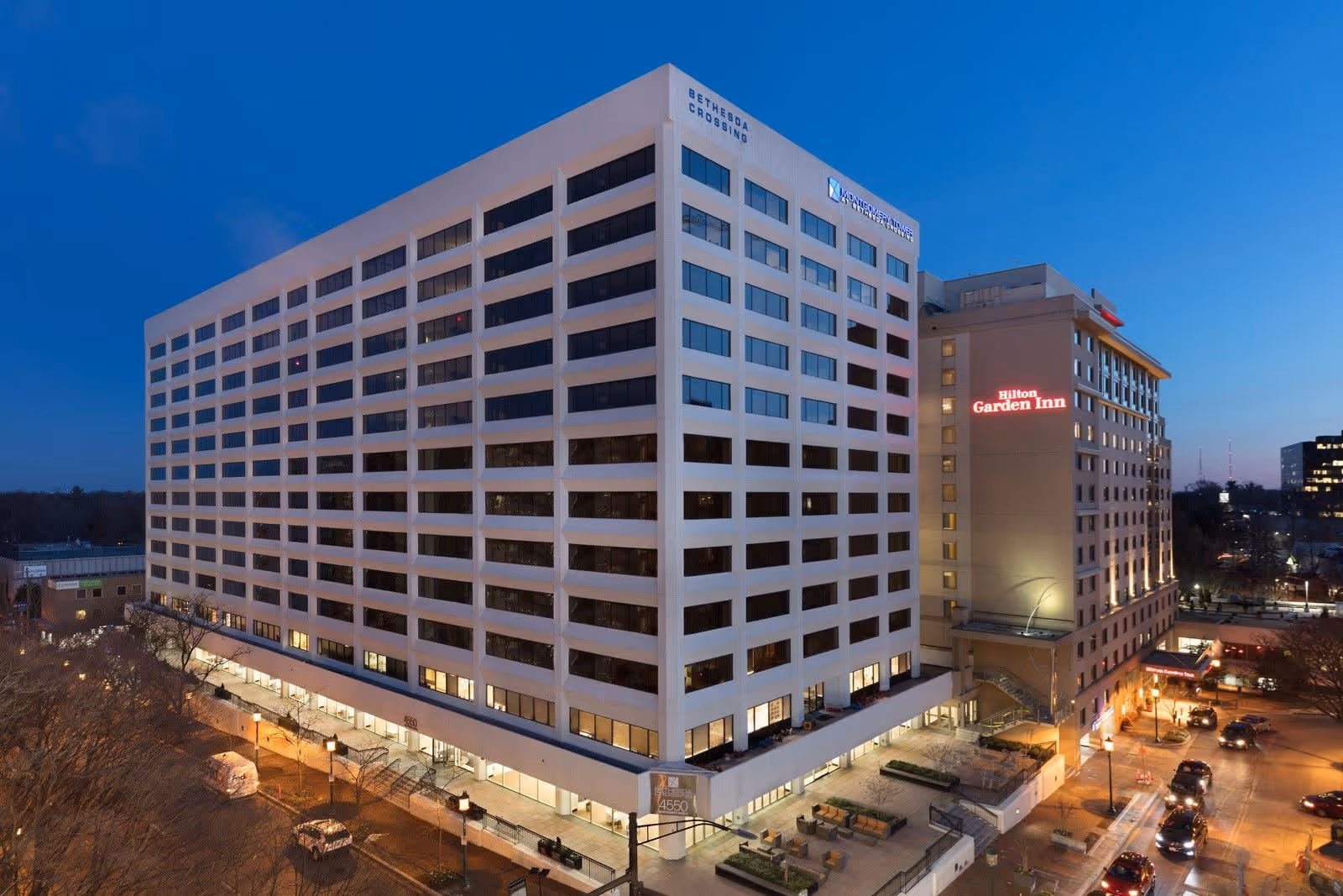 Aerial view of a hotel complex at dusk, with Hilton Garden Inn signage.