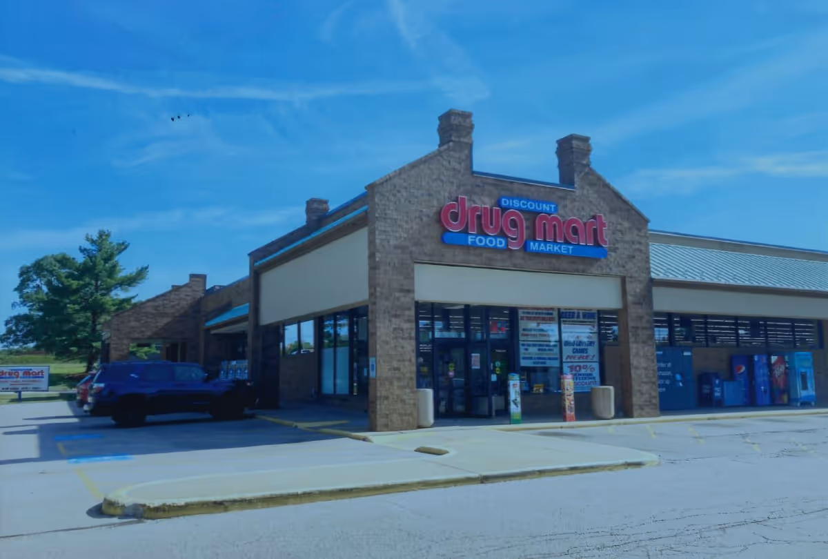 Exterior view of a Discount Drug Mart storefront with brick facade and blue signage.