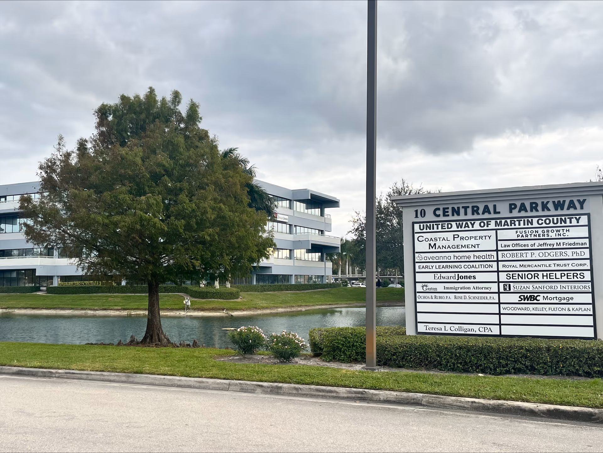 Exterior of Aveanna Home Health facility beside a pond with a large sign.