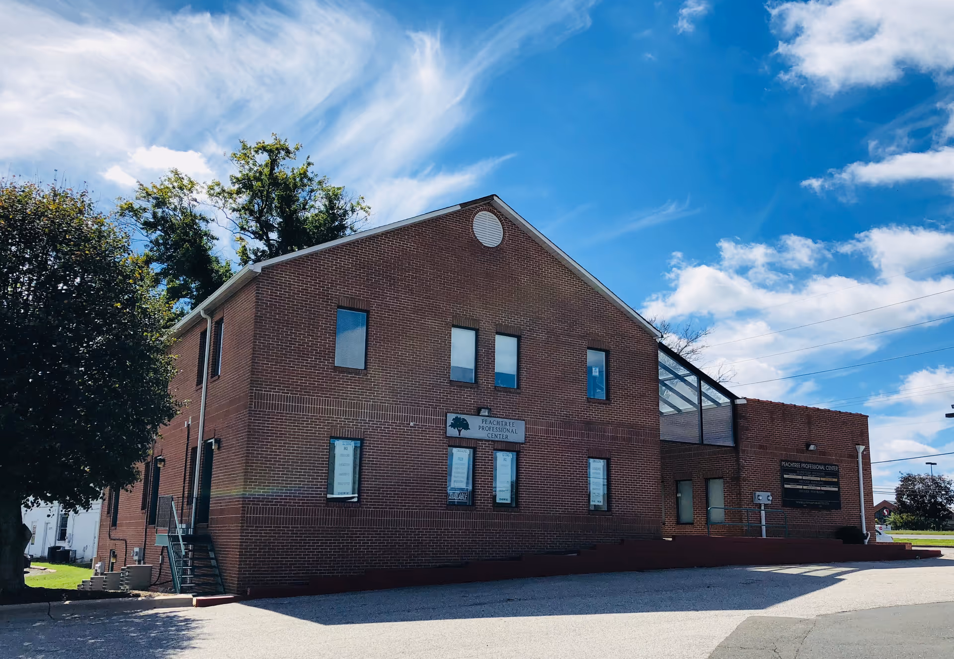 Brick senior care facility building with signage beneath a blue sky.