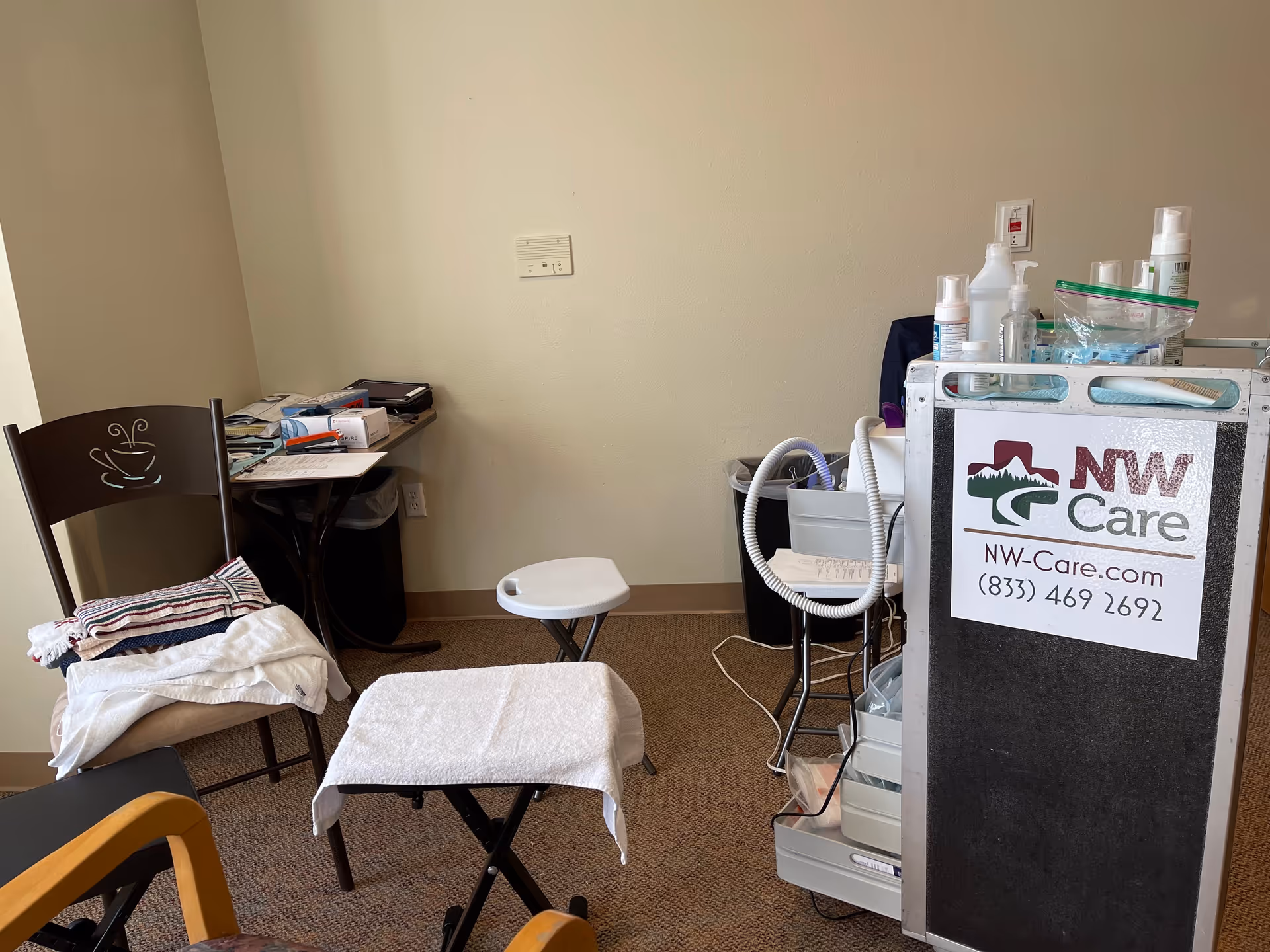 Podiatry treatment area in a senior living facility with medical cart and exam table.