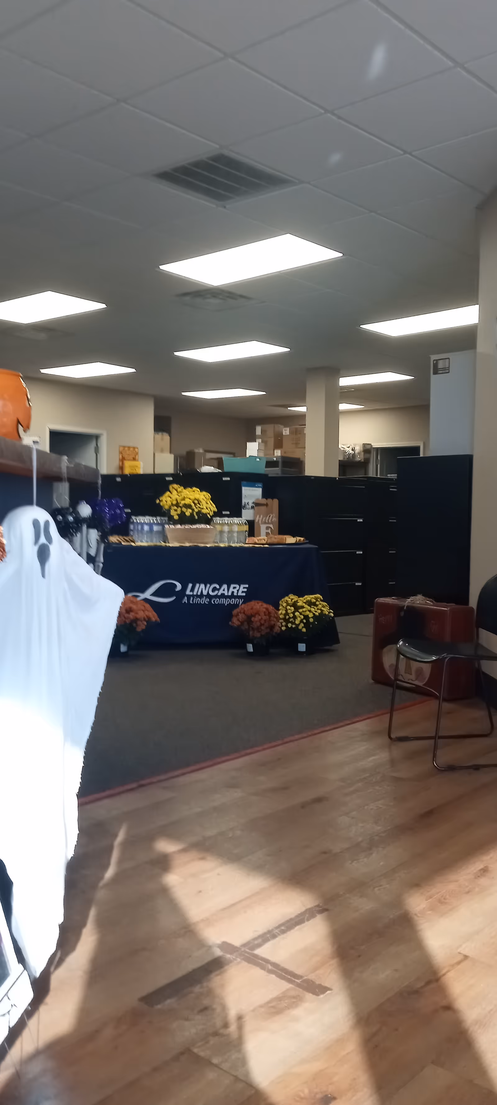 Reception area with a LINCARE display table, flowers, and supplies indoors.
