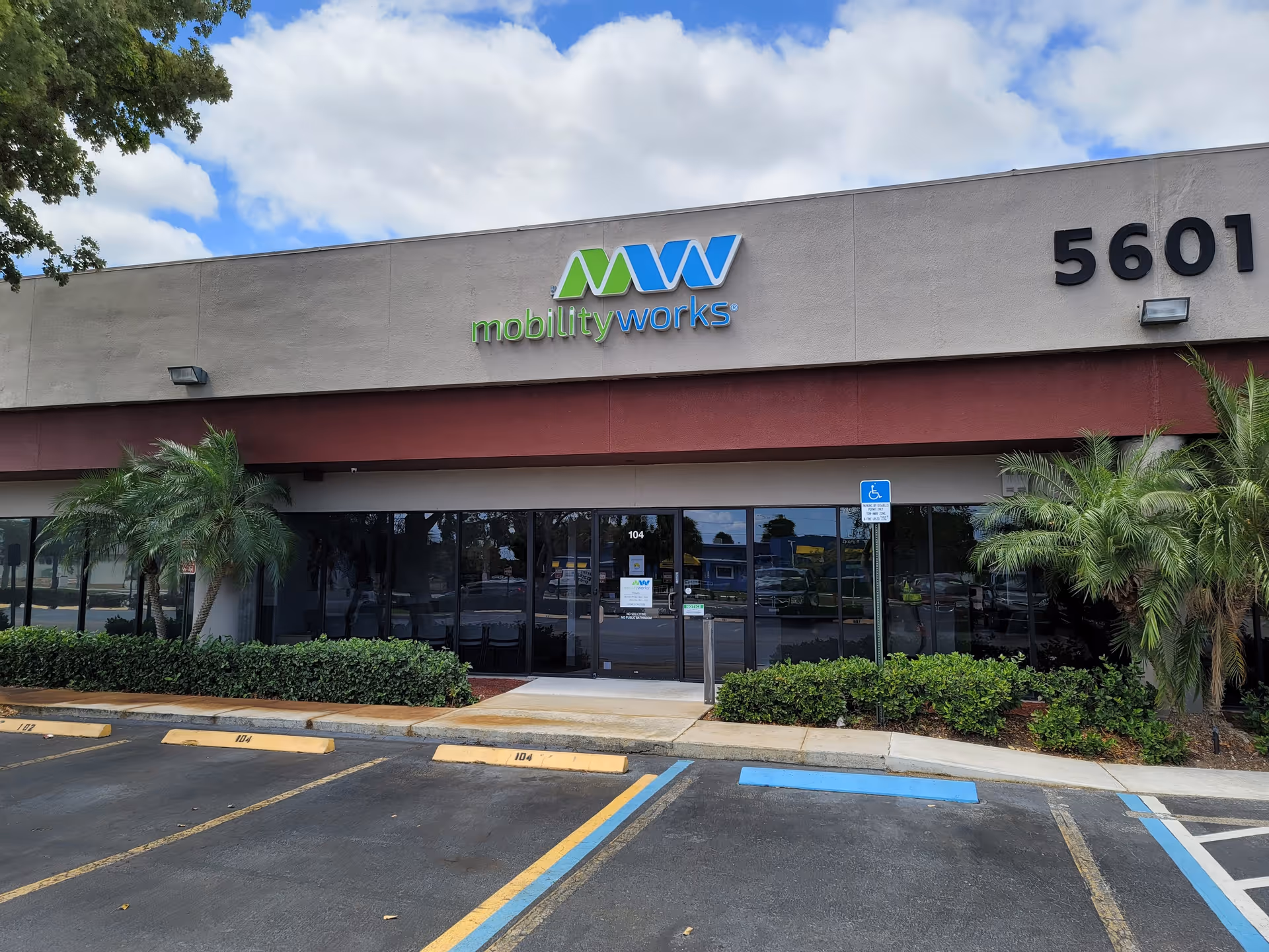Front exterior of MobilityWorks facility with glass doors and landscaping.