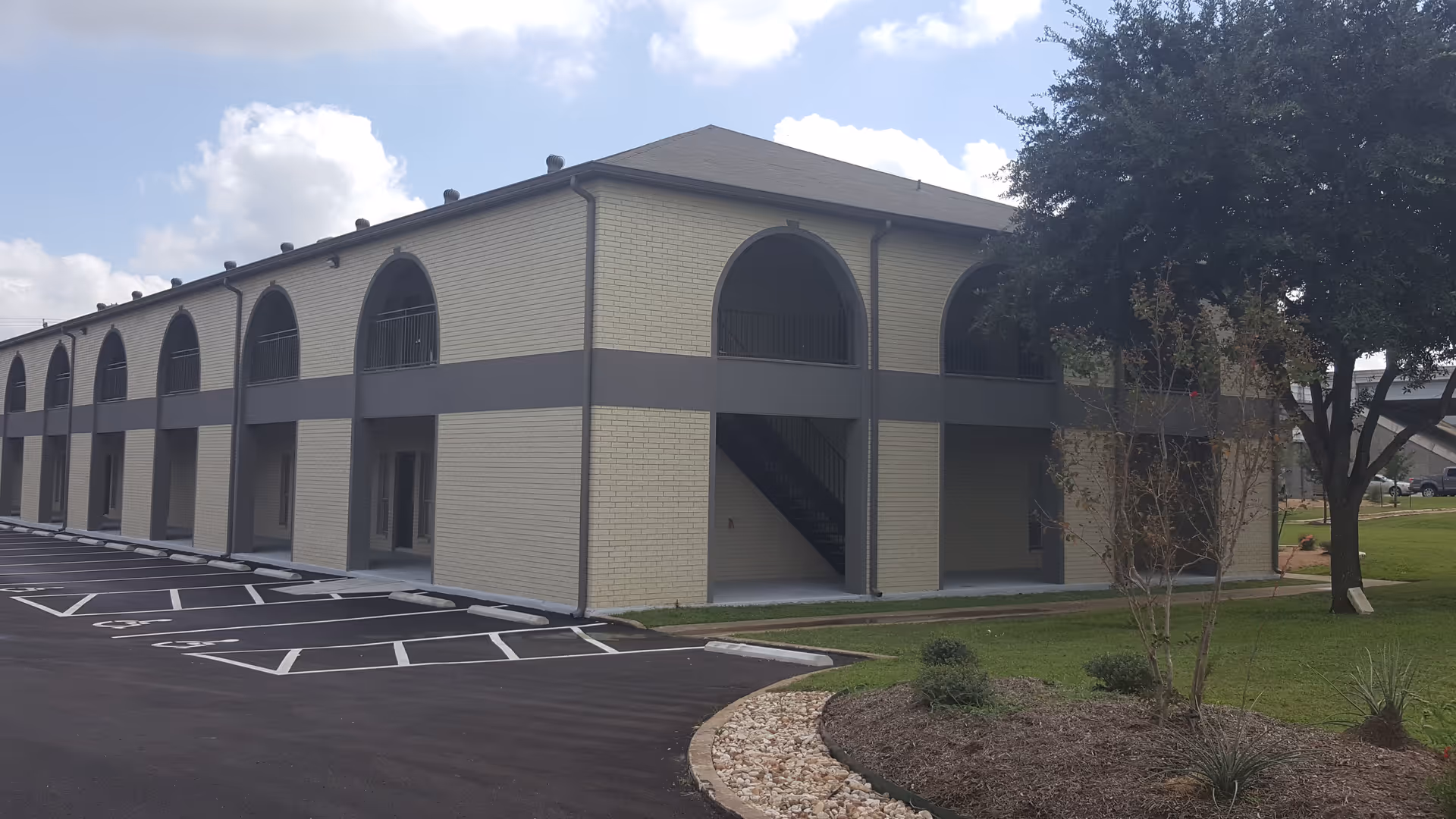 Exterior view of Comfort Keepers facility with arched windows, parking lot, and landscaping.