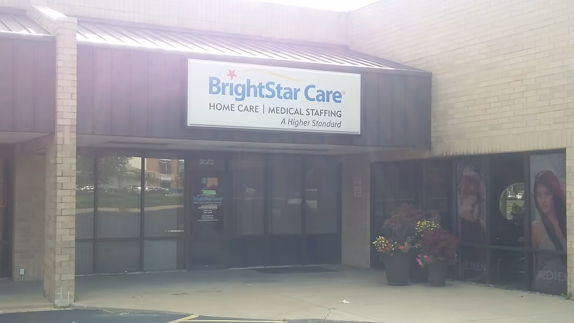 BrightStar Care storefront with sign and glass entrance, potted flowers outside