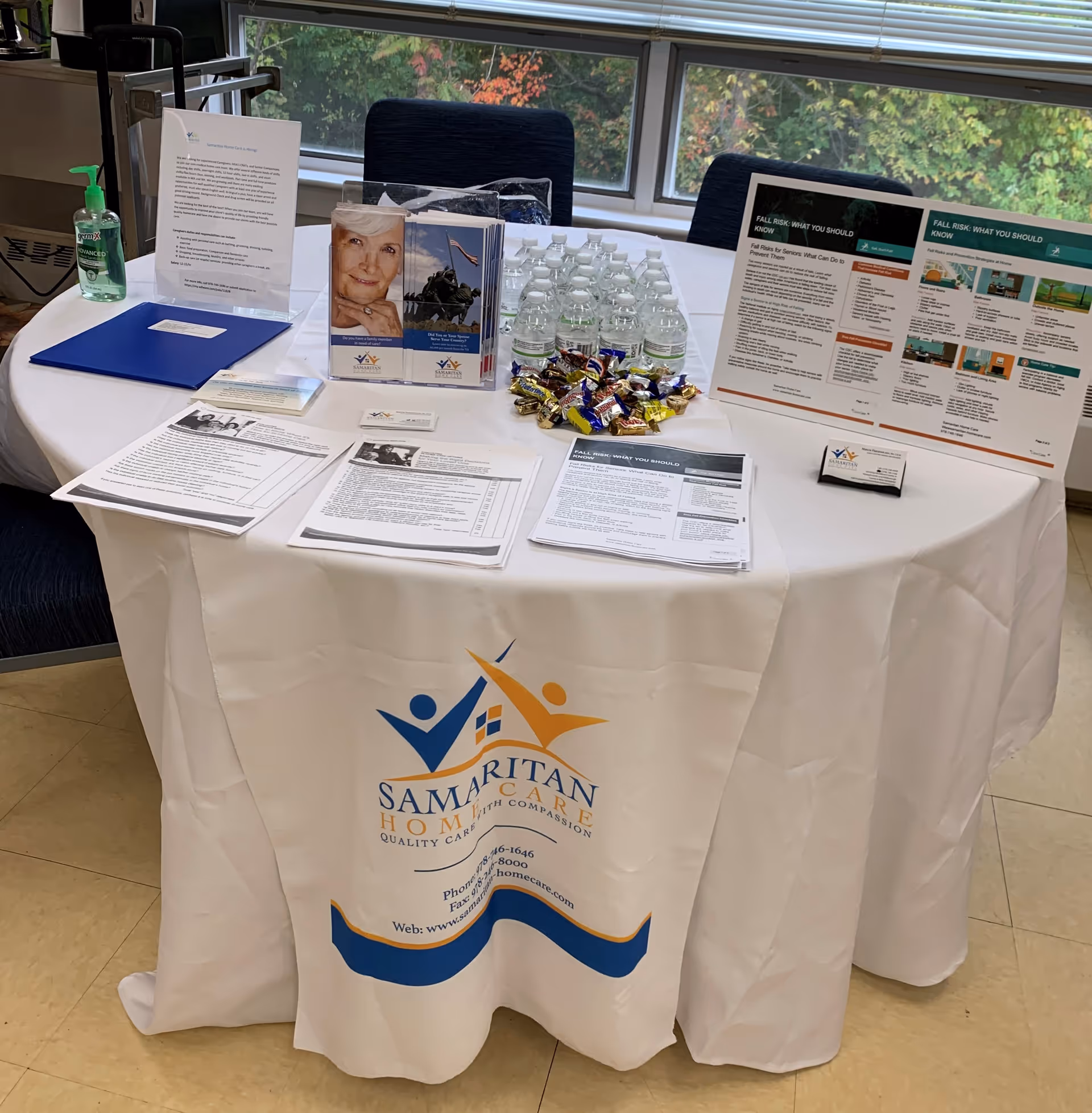 Table with brochures, water bottles, and candy at Samaritan Home Care information booth.