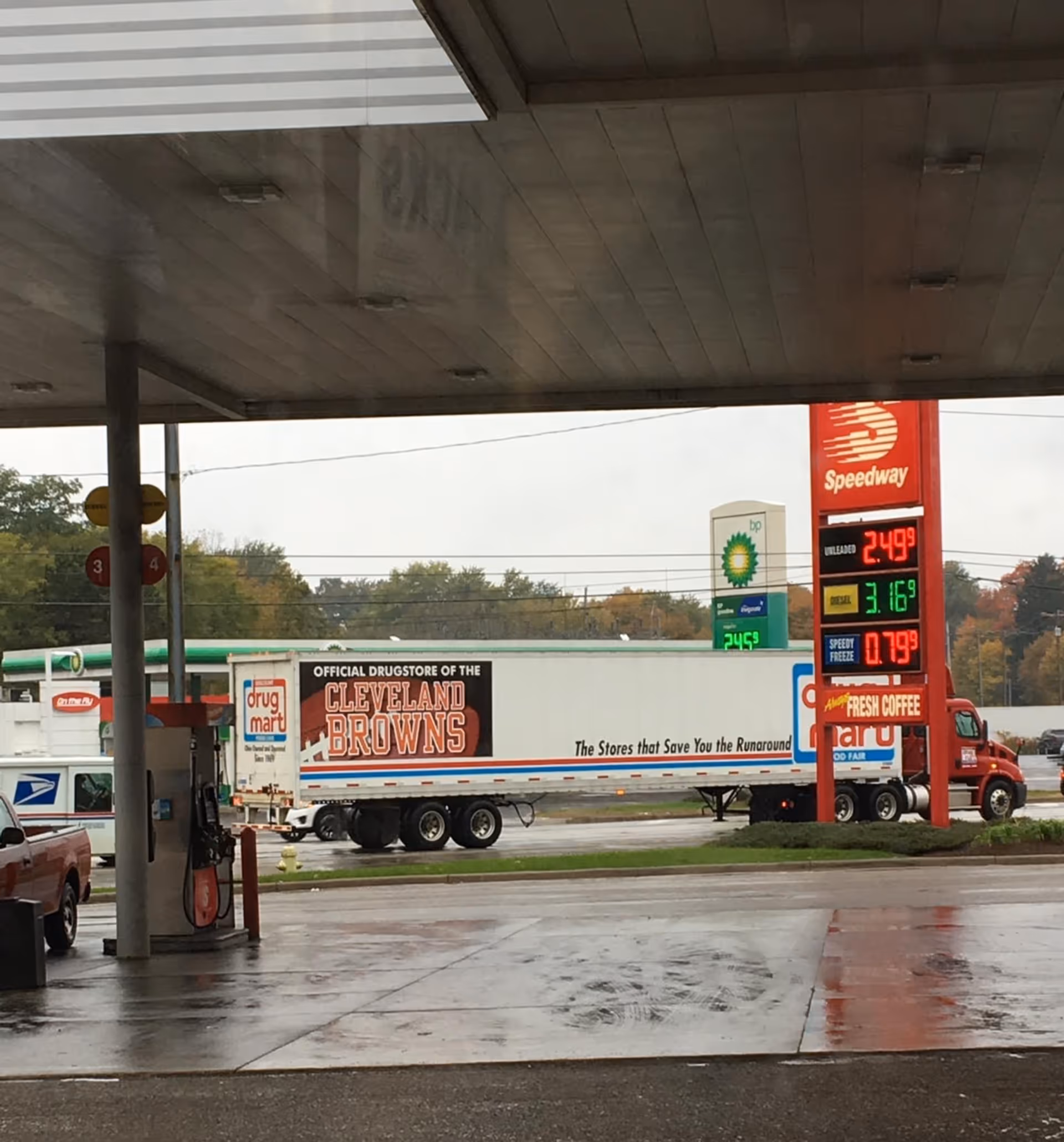 Gas station exterior with a Discount Drug Mart trailer and a Browns-branded truck.