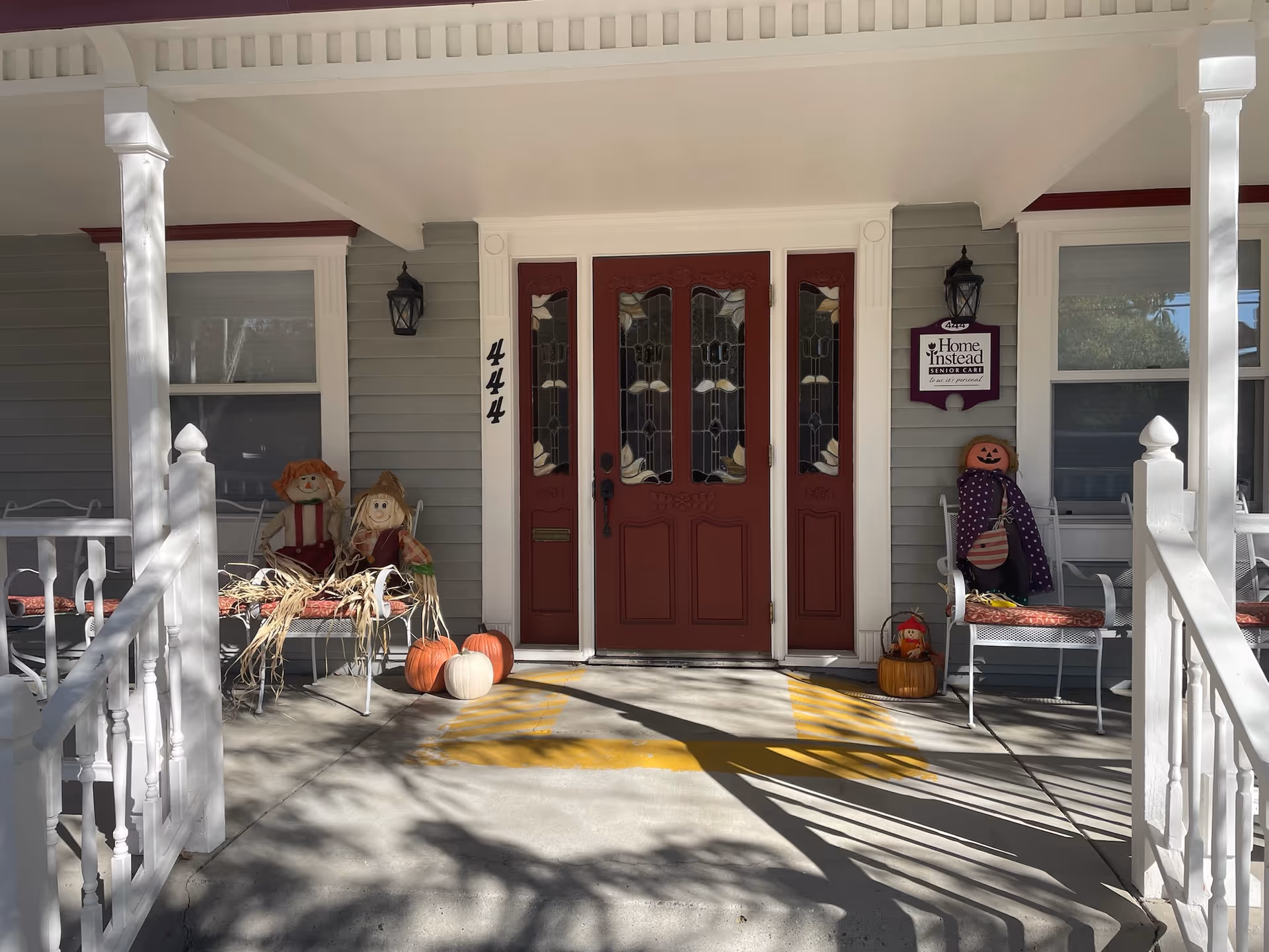 Front porch of a Home Instead Senior Care facility with pumpkins and Halloween decorations.