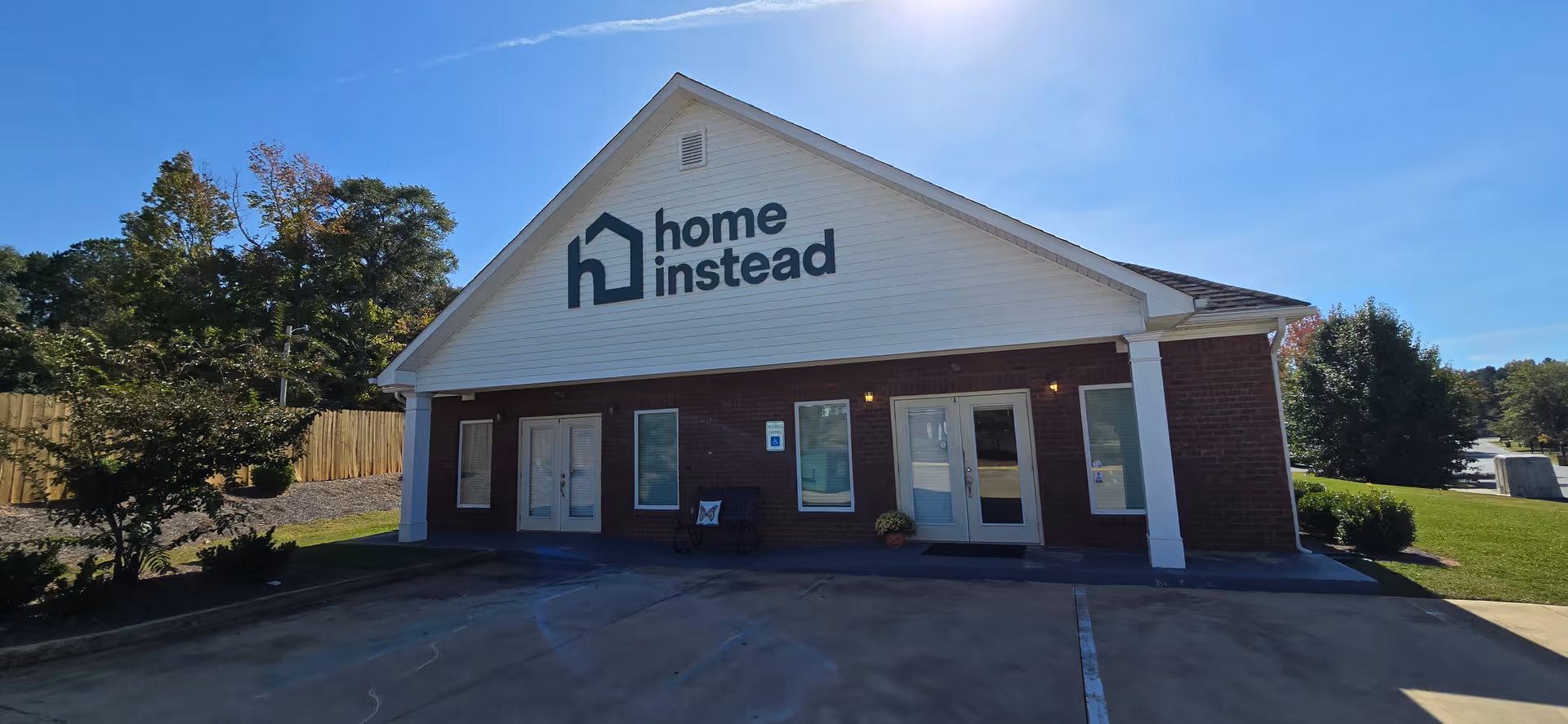 A single-story brick Home Instead facility with a large logo on the front facade.