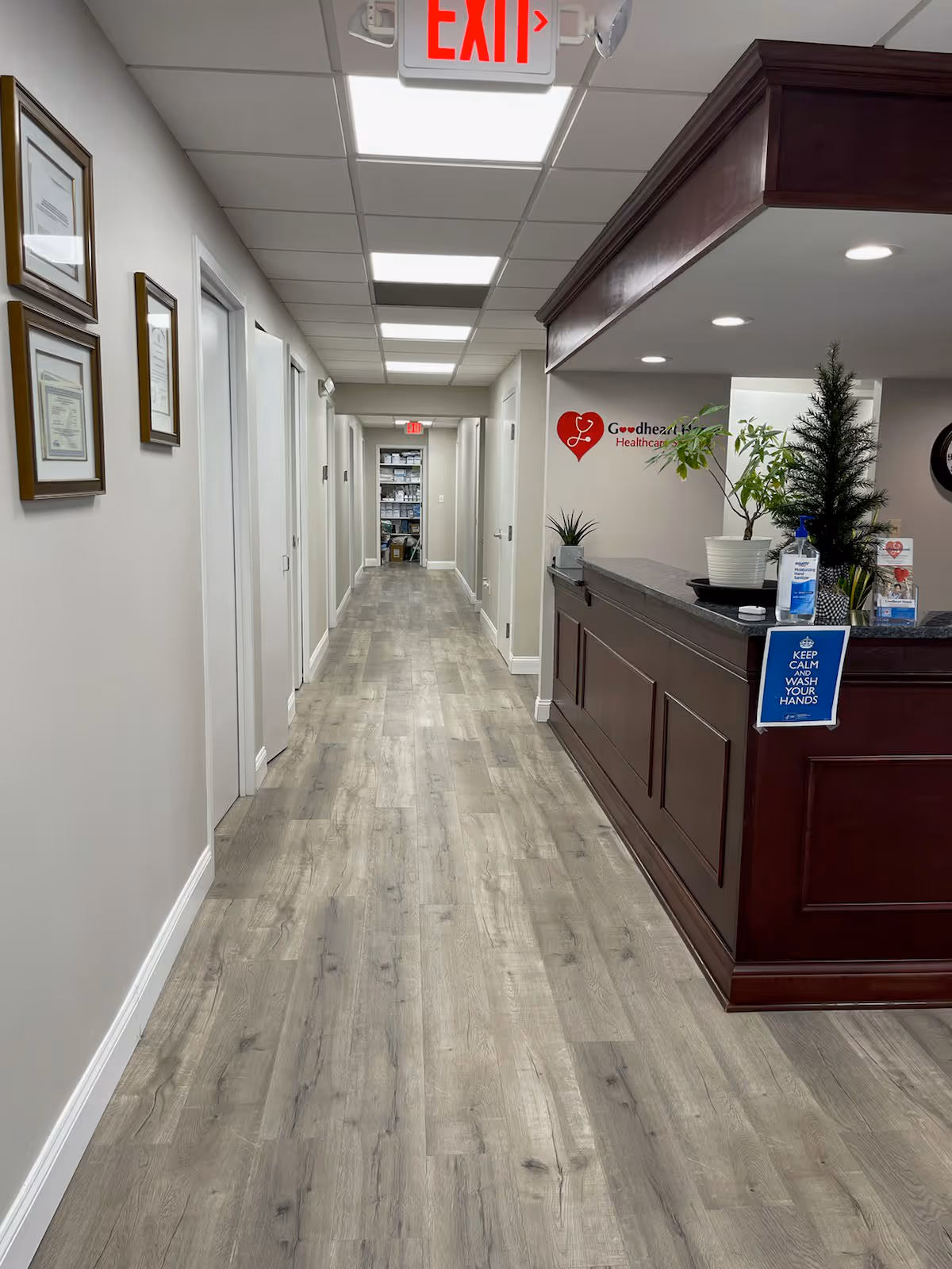 Interior hallway of Goodheart Home Healthcare with reception desk and exit sign.