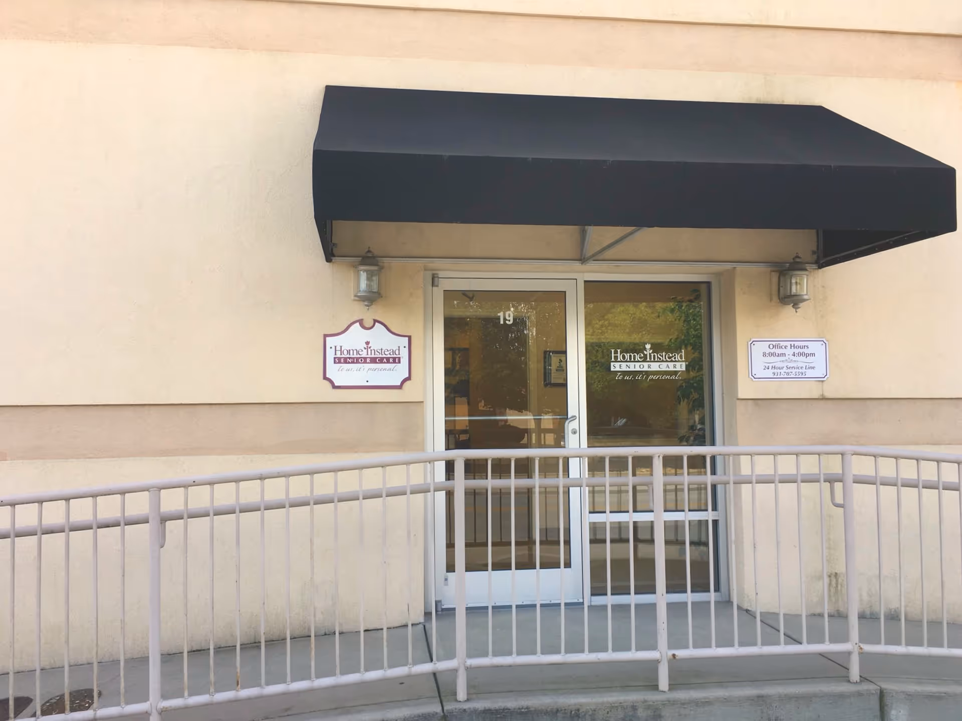 Front entrance of a Home Instead Senior Care facility with a black awning.