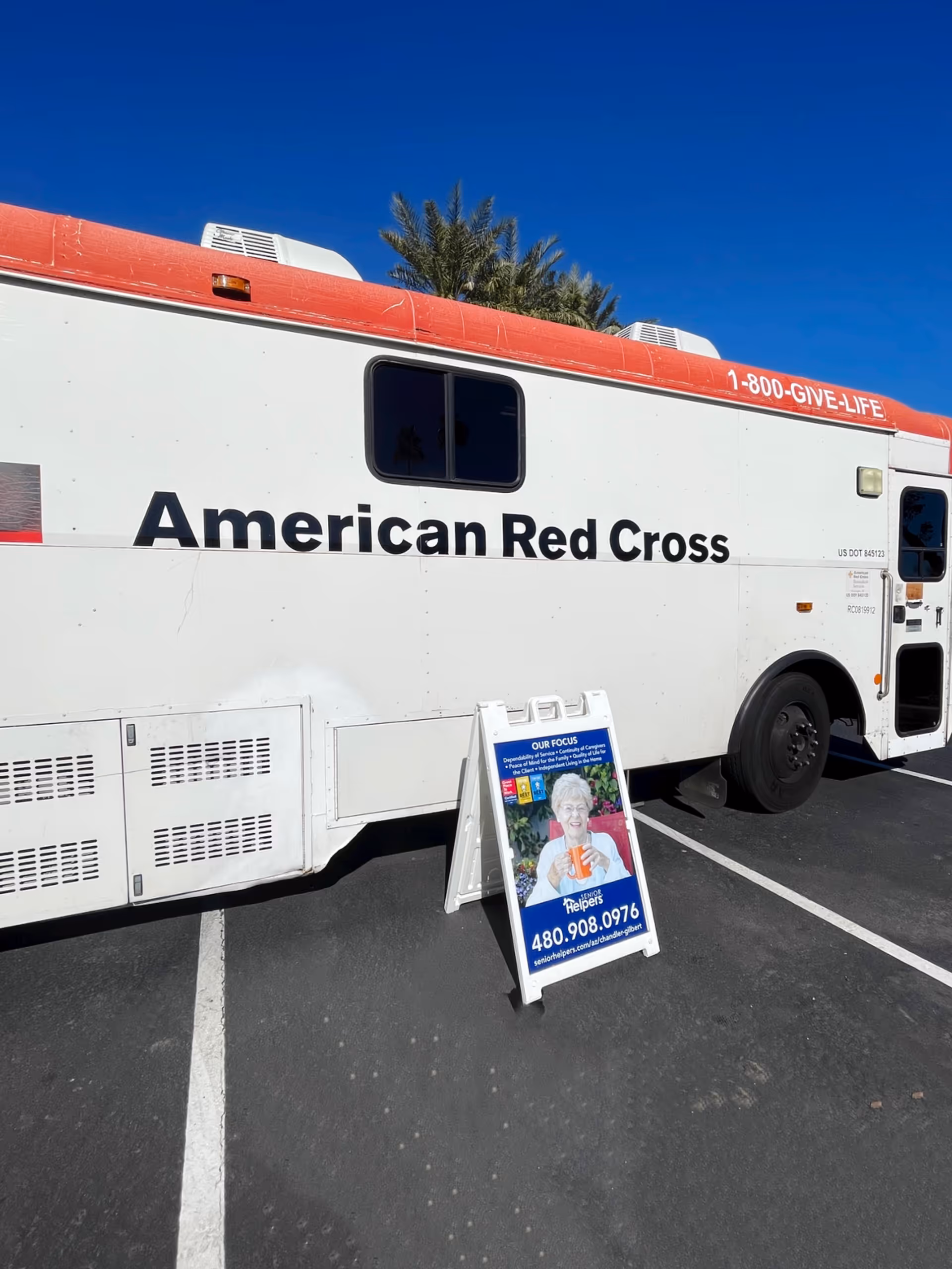 White American Red Cross mobile unit parked in a lot with a display sign.
