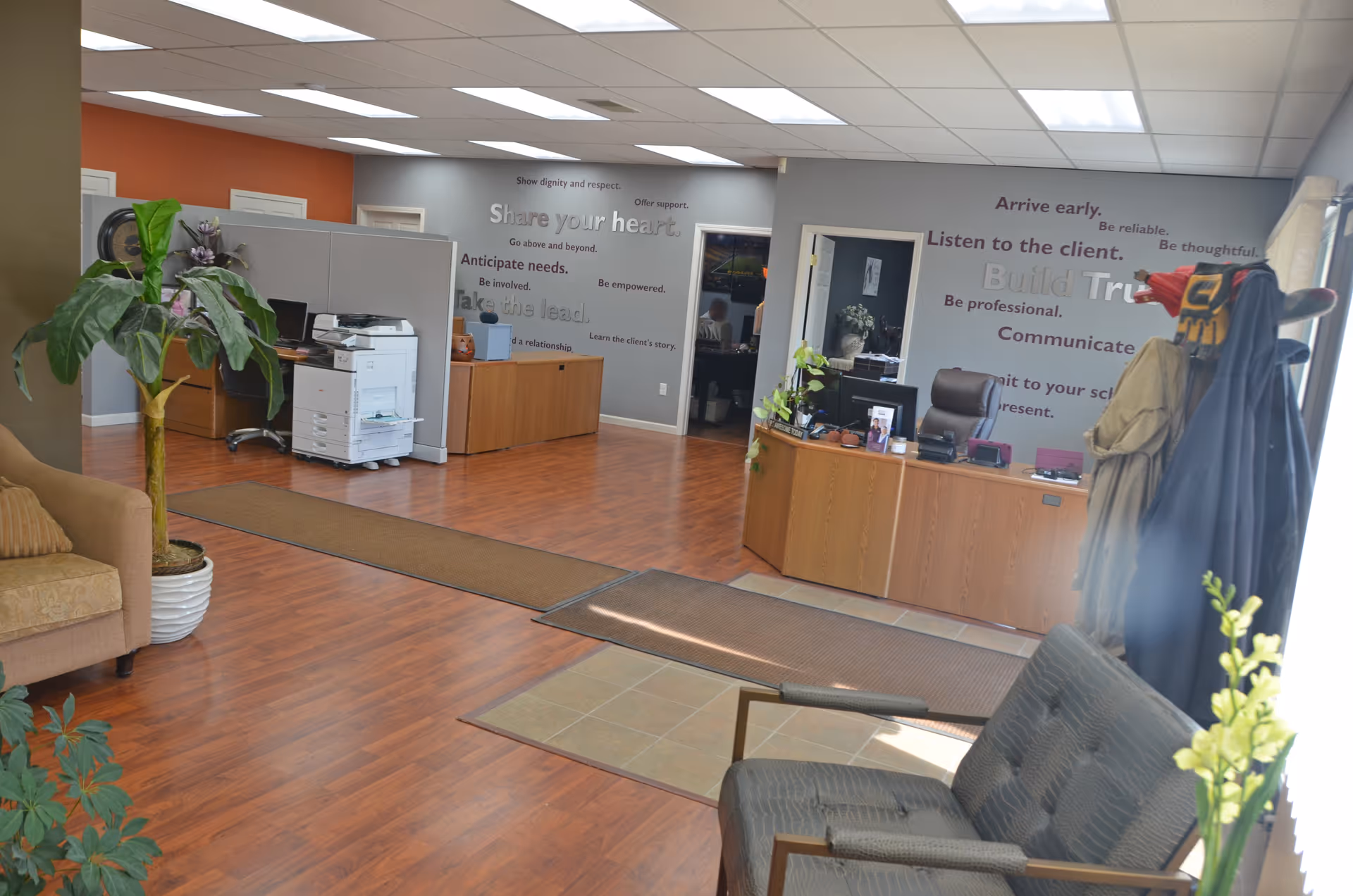 Reception area of a senior care facility with desks, seating, and plants.