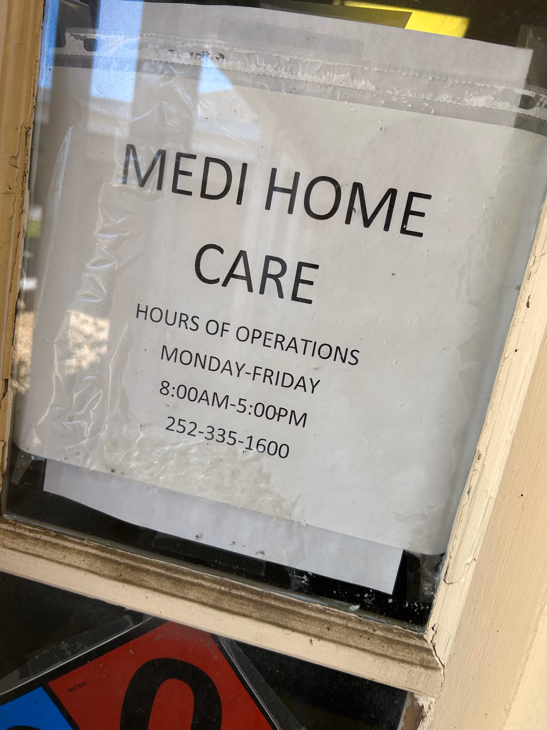 Window sign shows Medi Home Care hours and contact number.