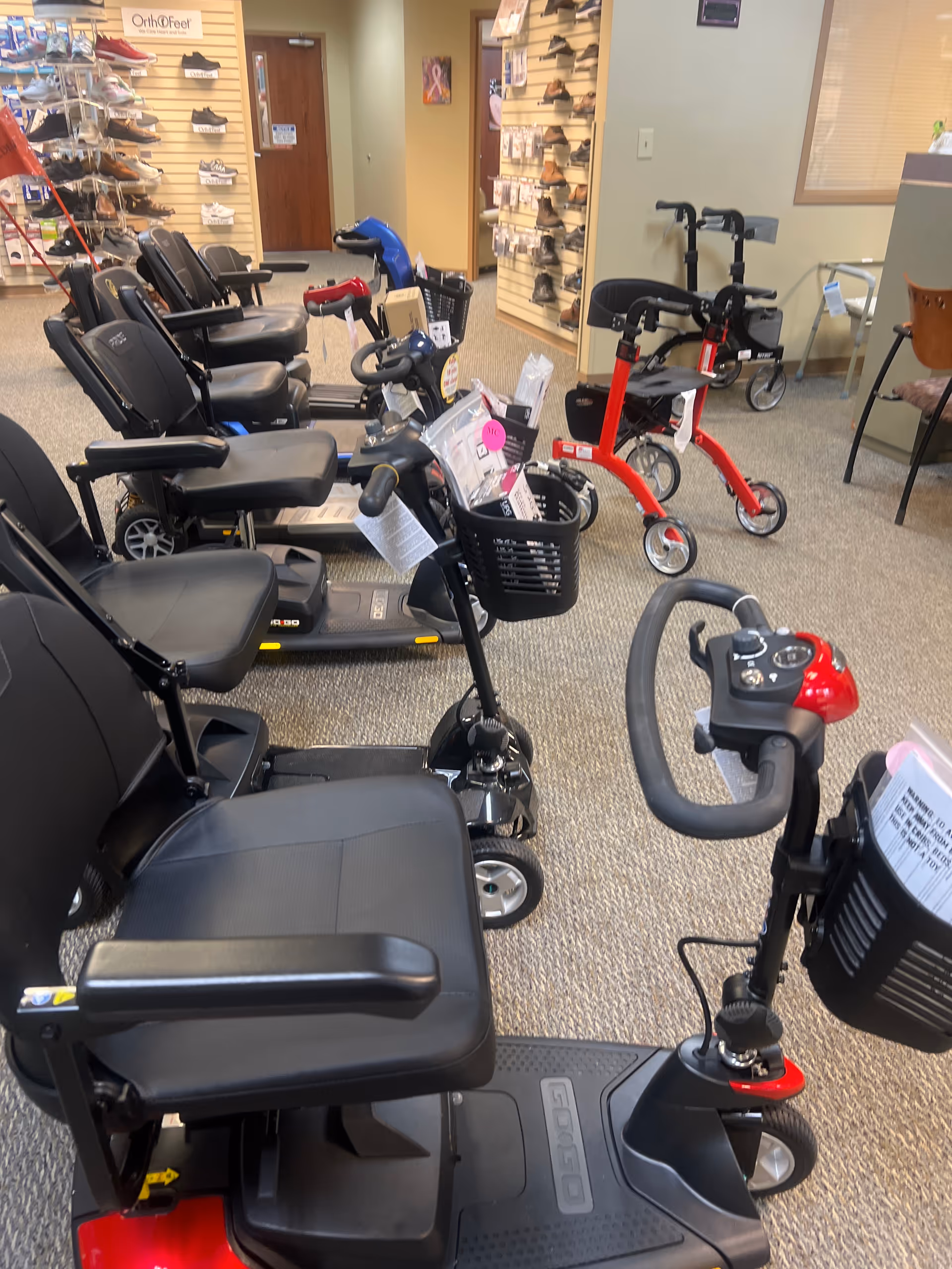 Interior view of a senior living facility equipment showroom with scooters and walkers.