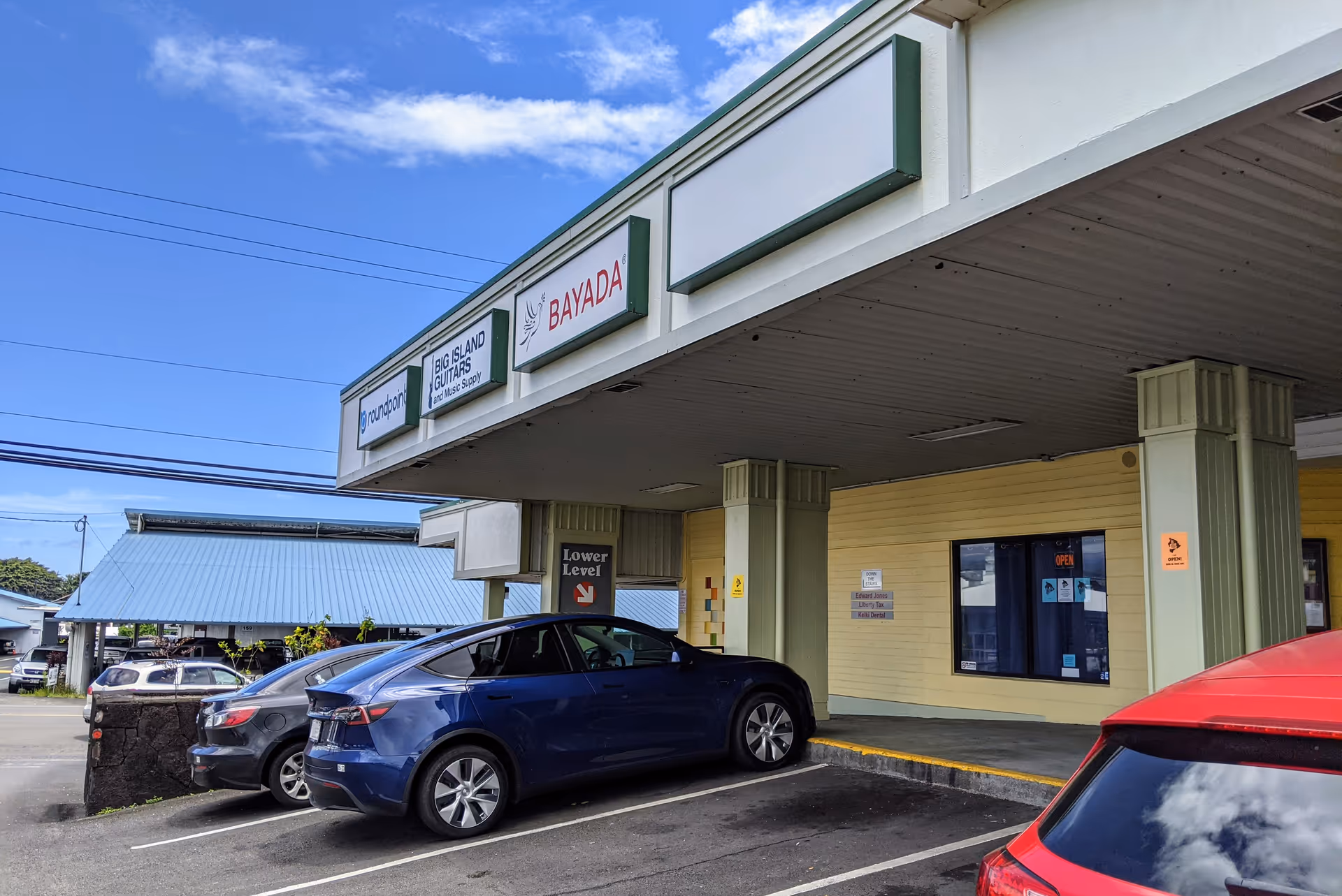 Exterior view of BAYADA Home Health building with signage, columned entrance, and parked cars.