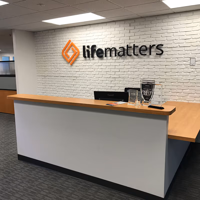 Reception desk in a lobby with a brick wall and lifematters sign.
