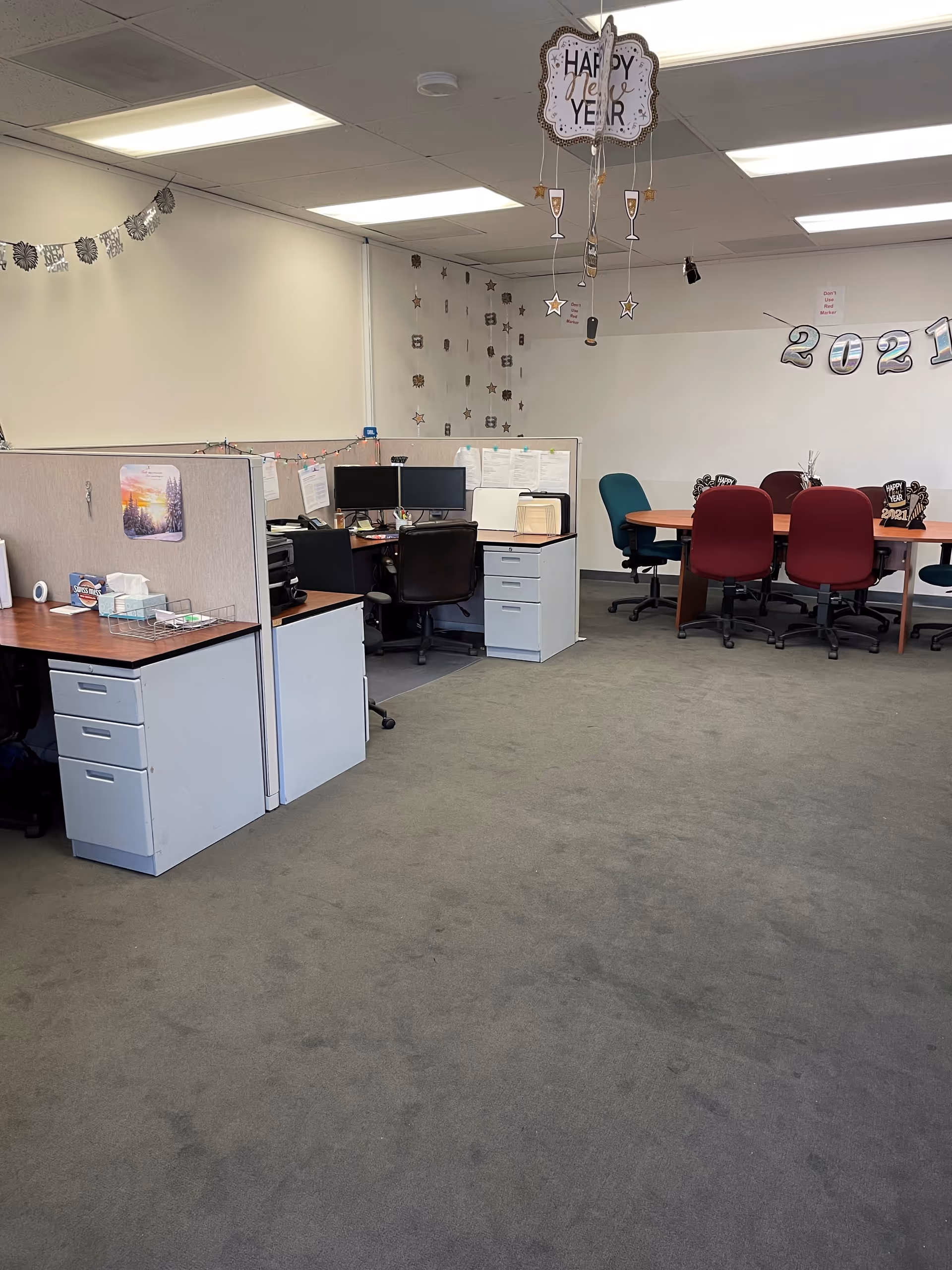 Office workspace with cubicles, desks, and New Year decorations.