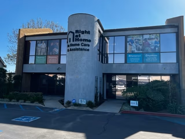 Two-story Right at Home building with signage, banners on windows, and central entrance.